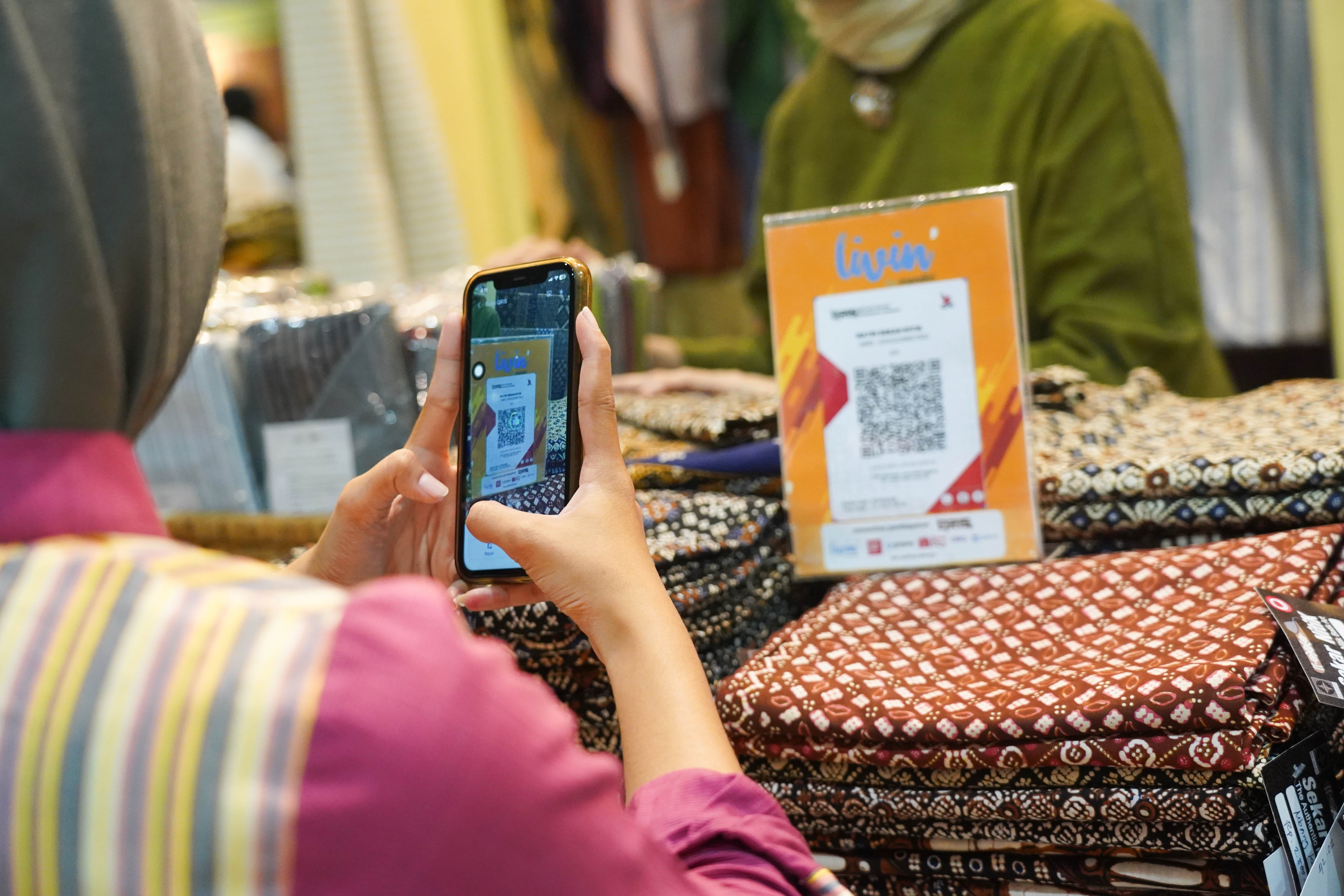 Pengunjung memindai kode batang pembayaran nontunai Quick Response Code Indonesia Standar (QRIS) saat melakukan transaksi pembelian produk pada Pameran Karya Kreatif Indonesia di Jakarta International Convention Center, Kamis (20/8/2026). Bank Indonesia (BI) memperluas MDR QRIS 0% untuk transaksi hingga Rp 100 ribu bagi seluruh kategori merchant yang akan berlaku mulai 1 Oktober 2026.