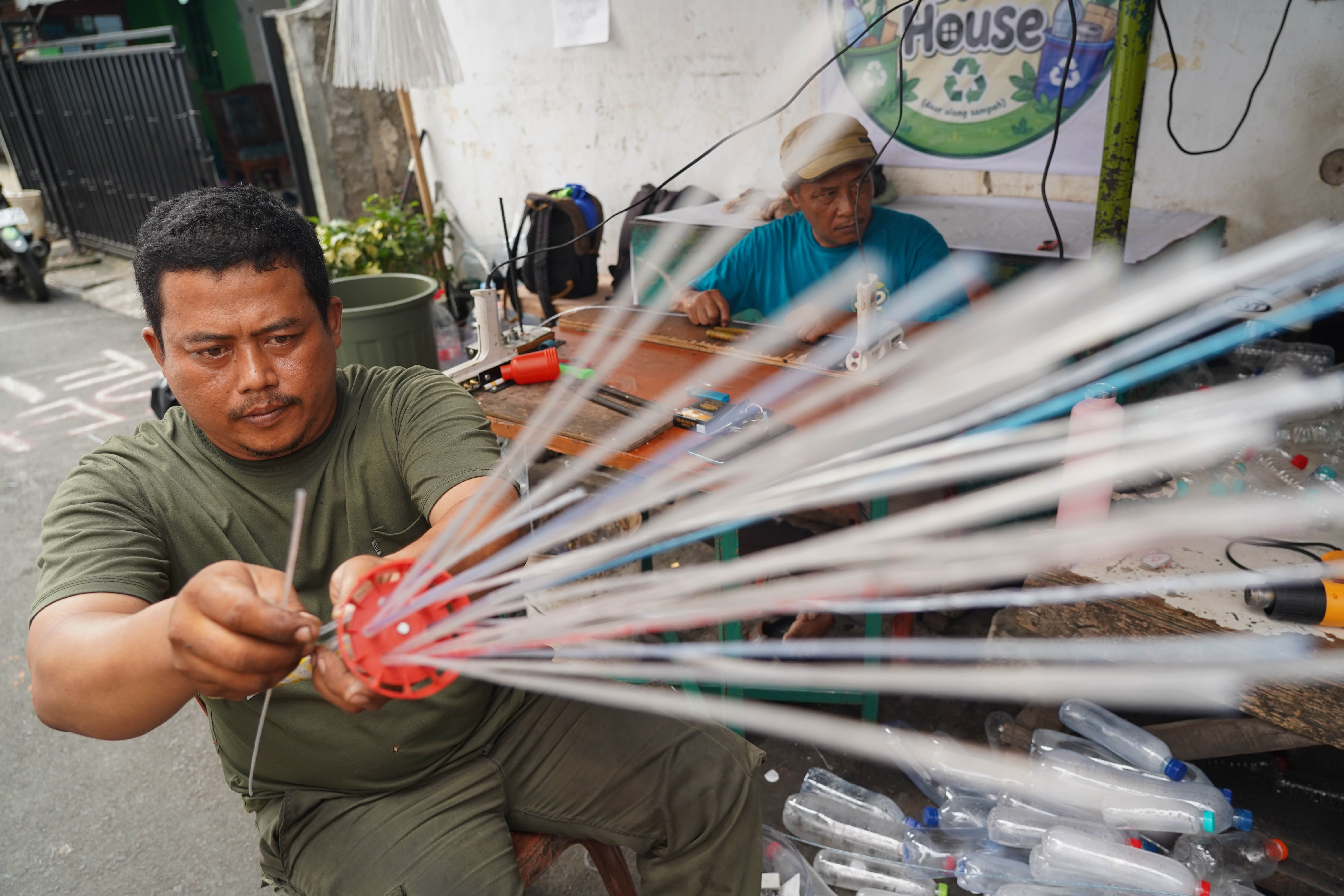 Warga menyelesaikan pembuatan sapu lidi dari daur ulang sampah botol plastik di pos siskamling kawasan RT.005/RW.002, Petukangan Utara, Jakarta Selatan, Rabu (19/8/2026). Kegiatan tersebut bertujuan untuk mengurangi sampah plastik dan mengasah kreatifitas serta keterampilan warga dalam mengubah barang bekas menjadi produk bernilai ekonomi.