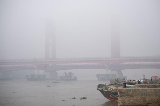 Warga berada di atas perahu tradisional dengan latar belakang jembatan Ampera Palembang yang tertutup kabut asap di kawasan 16 ilir Palembang, Sumatera Selatan, Minggu (23/8/2026). Berdasarkan citra satelit Himawari-9 yang dipantau BMKG pada Minggu (23/8) pukul 10:00 WIB, terdeteksi terjadi sebaran asap di wilayah Sumatera Selatan, Riau, Jambi, Kalimantan Barat, Kalimantan Tengah, Kalimantan Selata, Maluku, Papua Barat, Papua Tengah dan Papua Selatan akibat kebakaran hutan dan lahan yang terjadi di daerah t
