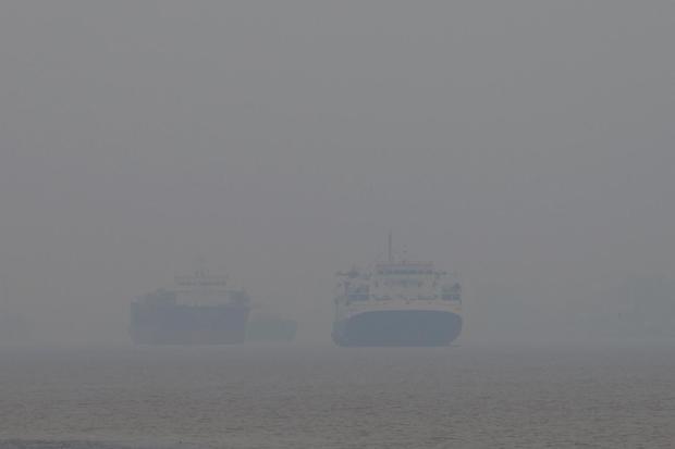 Dua kapal berlayar di Sungai Kapuas yang diselimuti kabut asap di Pontianak, Kalimantan Barat, Minggu (23/8/2026). Menurut warga setempat yang menggunakan transportasi sungai, kabut asap akibat kebakaran hutan dan lahan (karhutla) yang menyelimuti wilayah tersebut menyebabkan jarak pandang di kawasan perairan yang sebelumnya luas menjadi terbatas hingga sekitar 20-30 meter.