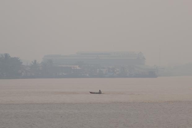 Sebuah perahu melintasi Sungai Kapuas yang diselimuti kabut asap di Pontianak, Kalimantan Barat, Minggu (23/8/2026). Menurut warga setempat yang menggunakan transportasi sungai, kabut asap akibat kebakaran hutan dan lahan (karhutla) yang menyelimuti wilayah tersebut menyebabkan jarak pandang di kawasan perairan yang sebelumnya luas menjadi terbatas hingga sekitar 20-30 meter.