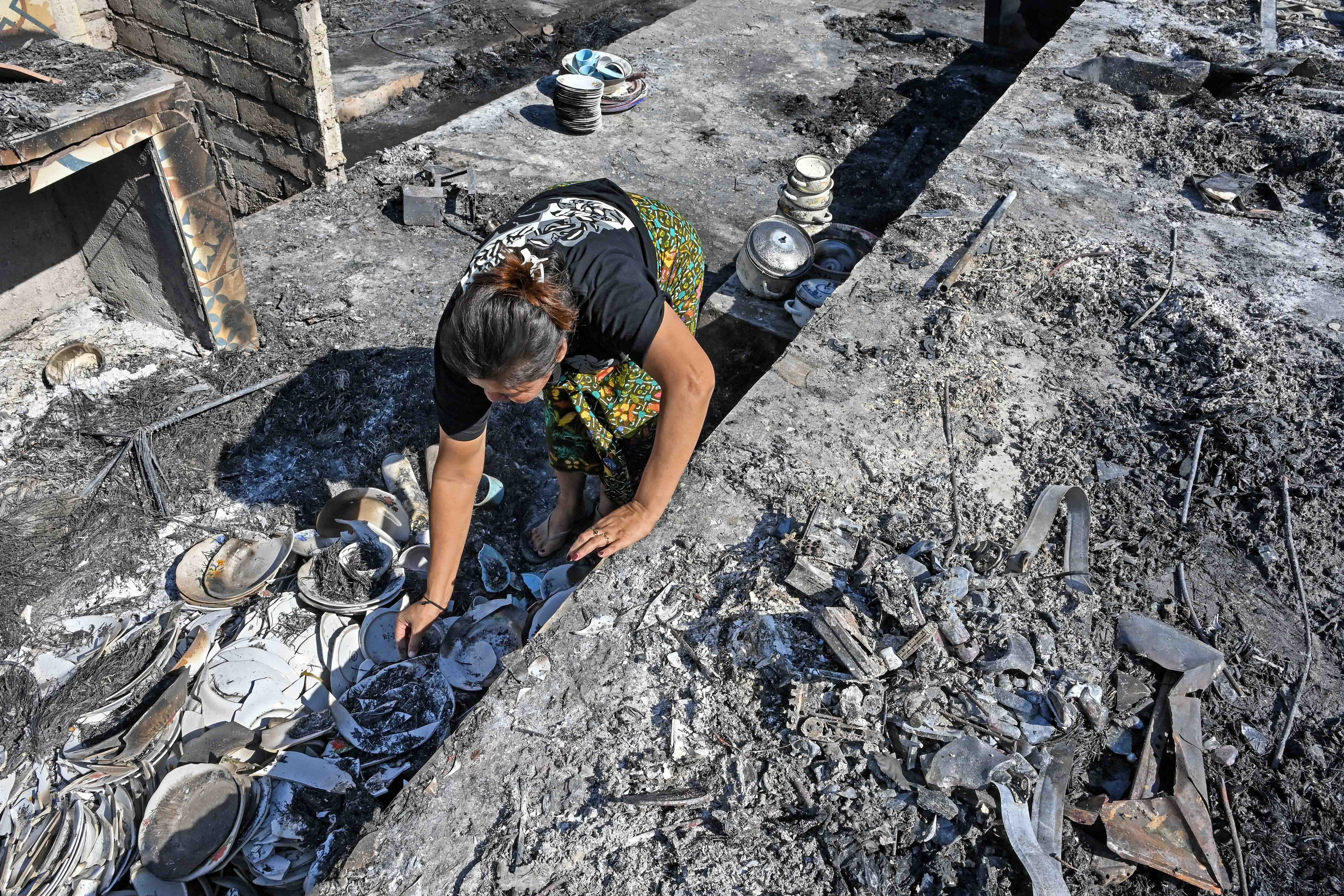 Warga mengais puing sisa barang-barang mereka yang terbakar di Desa Adat Sade, Rembitan, Kecamatan Pujut, Praya, Lombok Tengah, NTB, Minggu (23/8/2026). Kebakaran yang terjadi sekitar pukul 20.00 Wita Minggu (22/8) menghanguskan 120 bangunan di Desa Adat Sade yang sebagian besar menggunakan material kayu, bambu, bedek serta beratap ilalang dan tidak ada korban jiwa dalam peristiwa tersebut. 