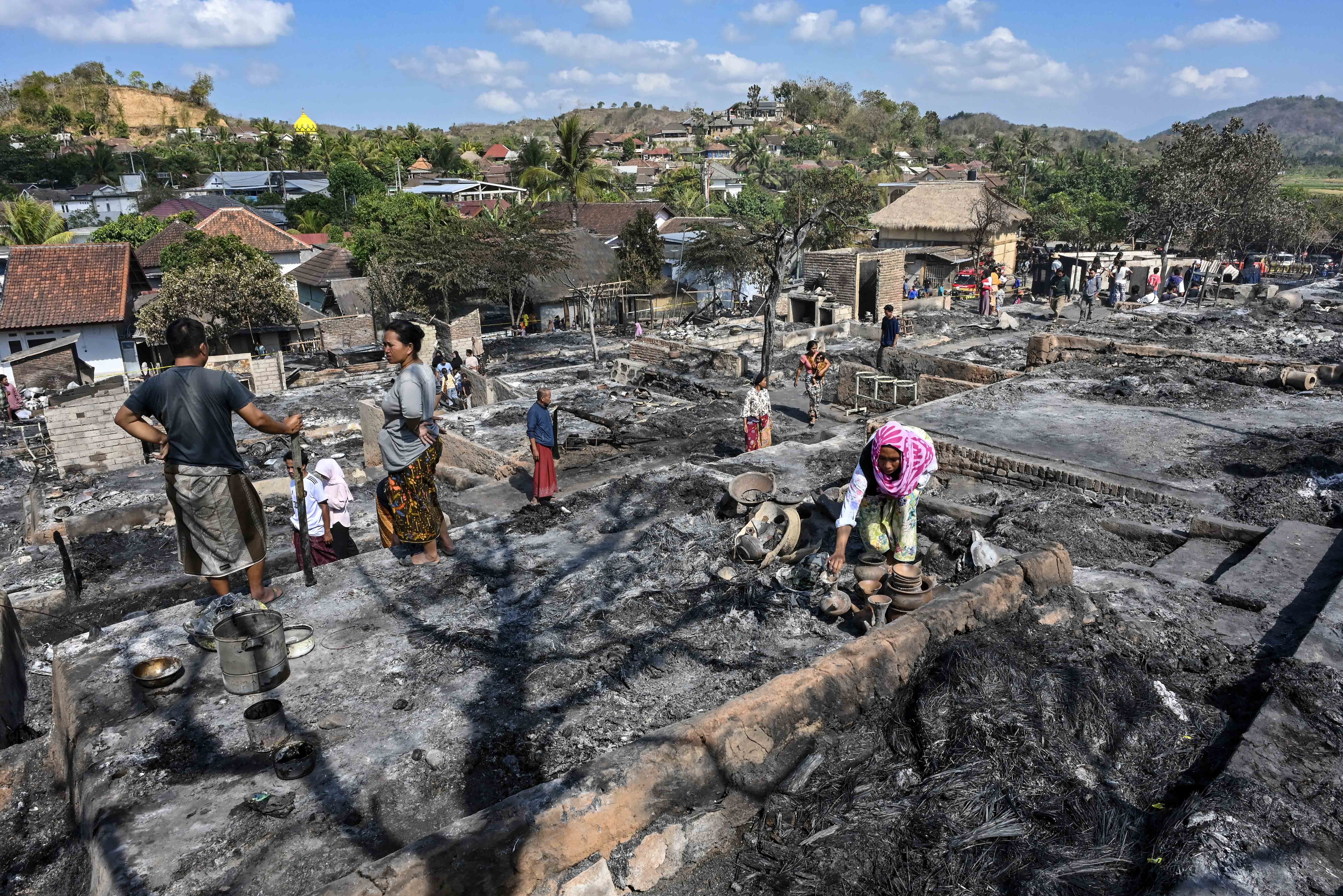 Warga mengais puing sisa barang-barang mereka yang terbakar di Desa Adat Sade, Rembitan, Kecamatan Pujut, Praya, Lombok Tengah, NTB, Minggu (23/8/2026). Kebakaran yang terjadi sekitar pukul 20.00 Wita Minggu (22/8) menghanguskan 120 bangunan di Desa Adat Sade yang sebagian besar menggunakan material kayu, bambu, bedek serta beratap ilalang dan tidak ada korban jiwa dalam peristiwa tersebut. 