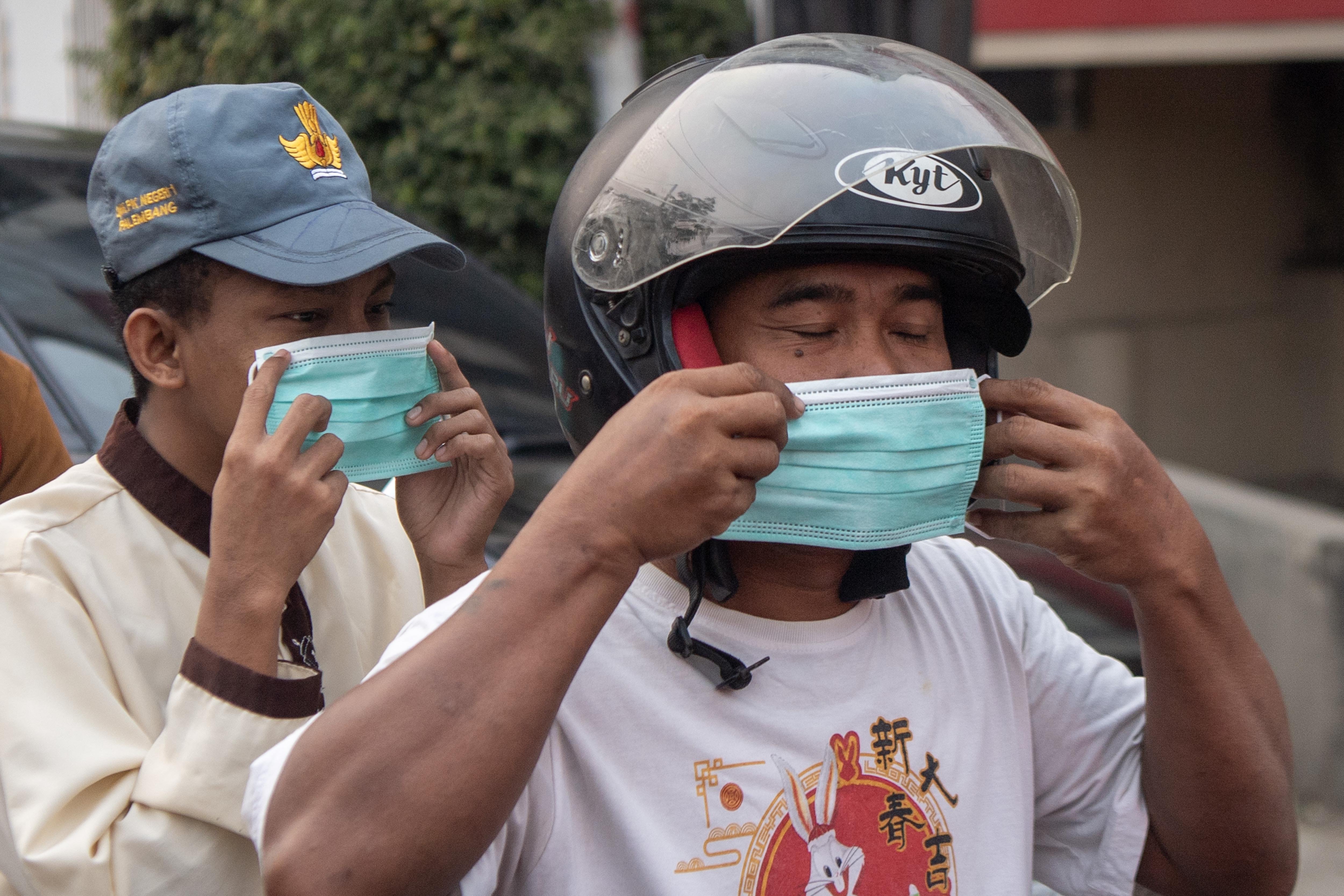 Pengendara memakai masker saat pembagian masker gratis di simpang empat RS Charitas Palembang, Sumatera Selatan, Senin (24/8/2026). Pemerintah Kota Palembang membagikan 16.500 masker kepada masyarakat untuk mencegah terjangkitnya penyakit Infeksi Saluran Pernapasan Akut akibat bencana kabut asap di Palembang dampak Kebakaran Hutan dan Lahan yang terjadi di sejumlah Kabupatan/Kota yang ada di Sumatera Selatan.