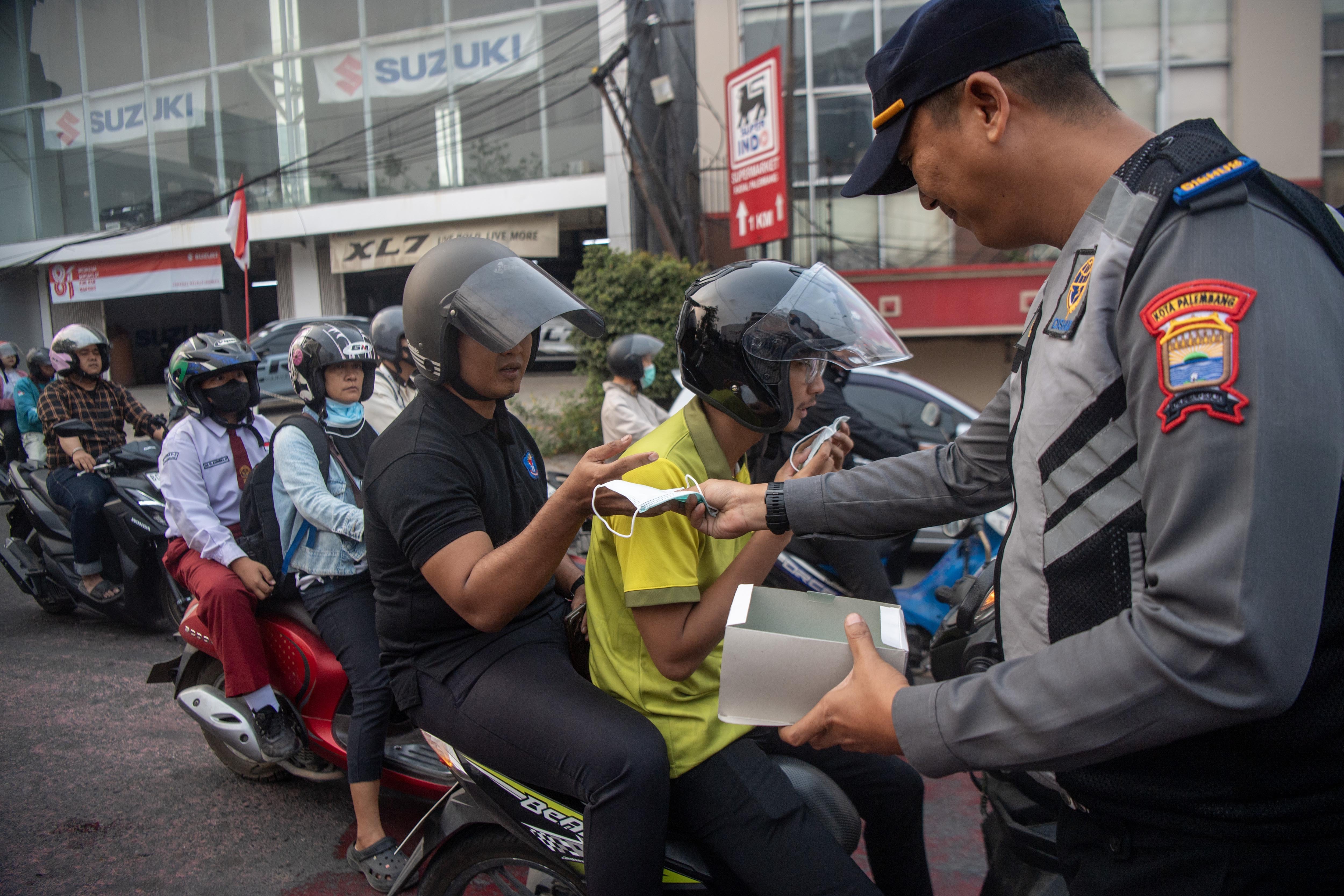 Petugas membagikan masker kepada pengendara di simpang empat RS Charitas Palembang, Sumatera Selatan, Senin (24/8/2026). Pemerintah Kota Palembang membagikan 16.500 masker kepada masyarakat untuk mencegah terjangkitnya penyakit Infeksi Saluran Pernapasan Akut akibat bencana kabut asap di Palembang dampak Kebakaran Hutan dan Lahan yang terjadi di sejumlah Kabupatan/Kota yang ada di Sumatera Selatan.
