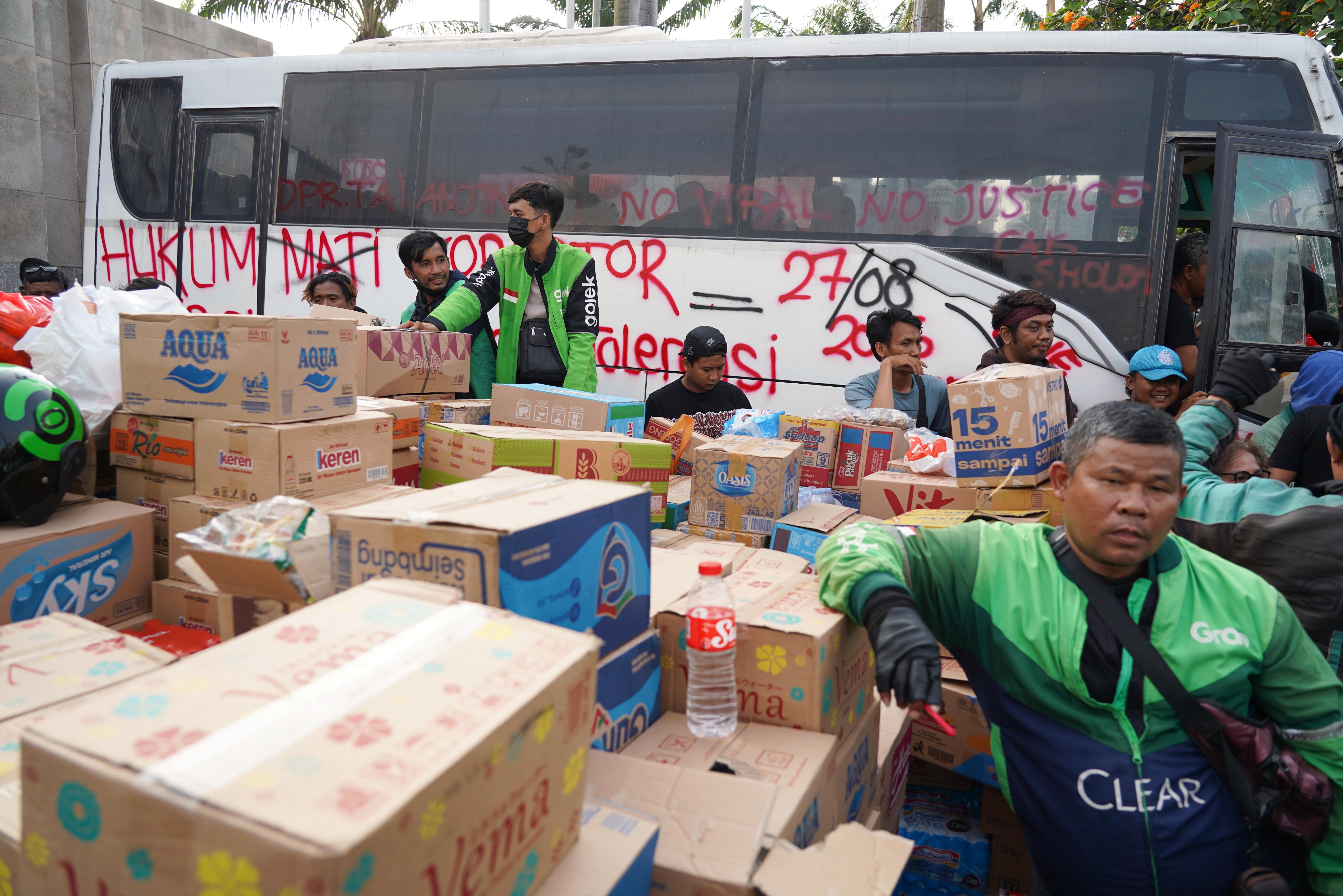 Pengemudi ojek online mengumpulkan air mineral yang didonasikan oleh warga untuk pengunjuk rasa di kawasan Gerbang DPR, Jakarta, Rabu (26/8/2026). Pada aksi yang akan digelar pada Kamis (27/8) oleh massa Aliansi Masyarakat Pati Bersatu (AMPB) ini menyerukan sejumlah tuntutan yang berkaitan dengan pemberantasan korupsi dan pembentukan regulasi mengenai perampasan aset.