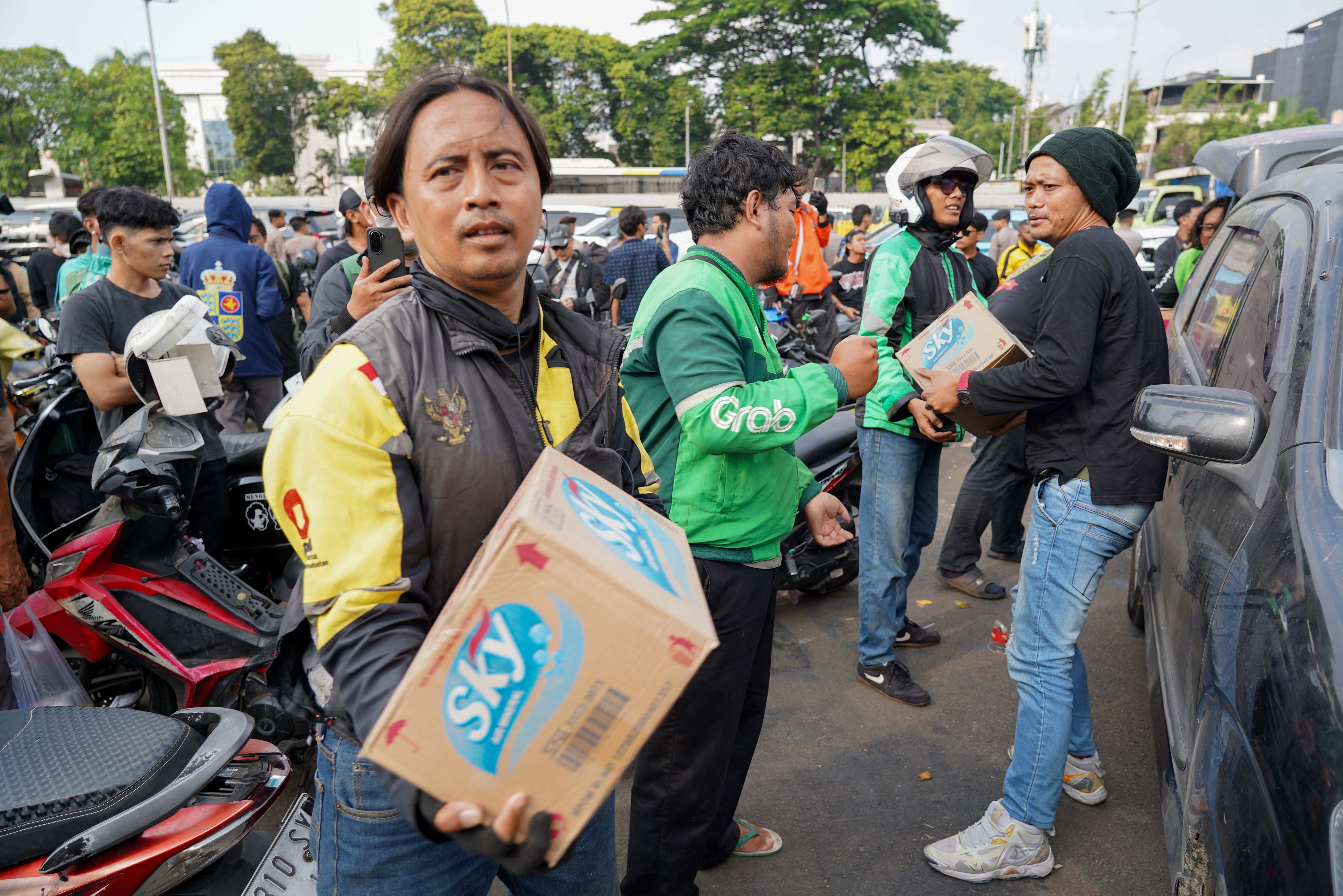 Pengemudi ojek online mengumpulkan air mineral yang didonasikan oleh warga untuk pengunjuk rasa di kawasan Gerbang DPR, Jakarta, Rabu (26/8/2026). Pada aksi yang akan digelar pada Kamis (27/8) oleh massa Aliansi Masyarakat Pati Bersatu (AMPB) ini menyerukan sejumlah tuntutan yang berkaitan dengan pemberantasan korupsi dan pembentukan regulasi mengenai perampasan aset.