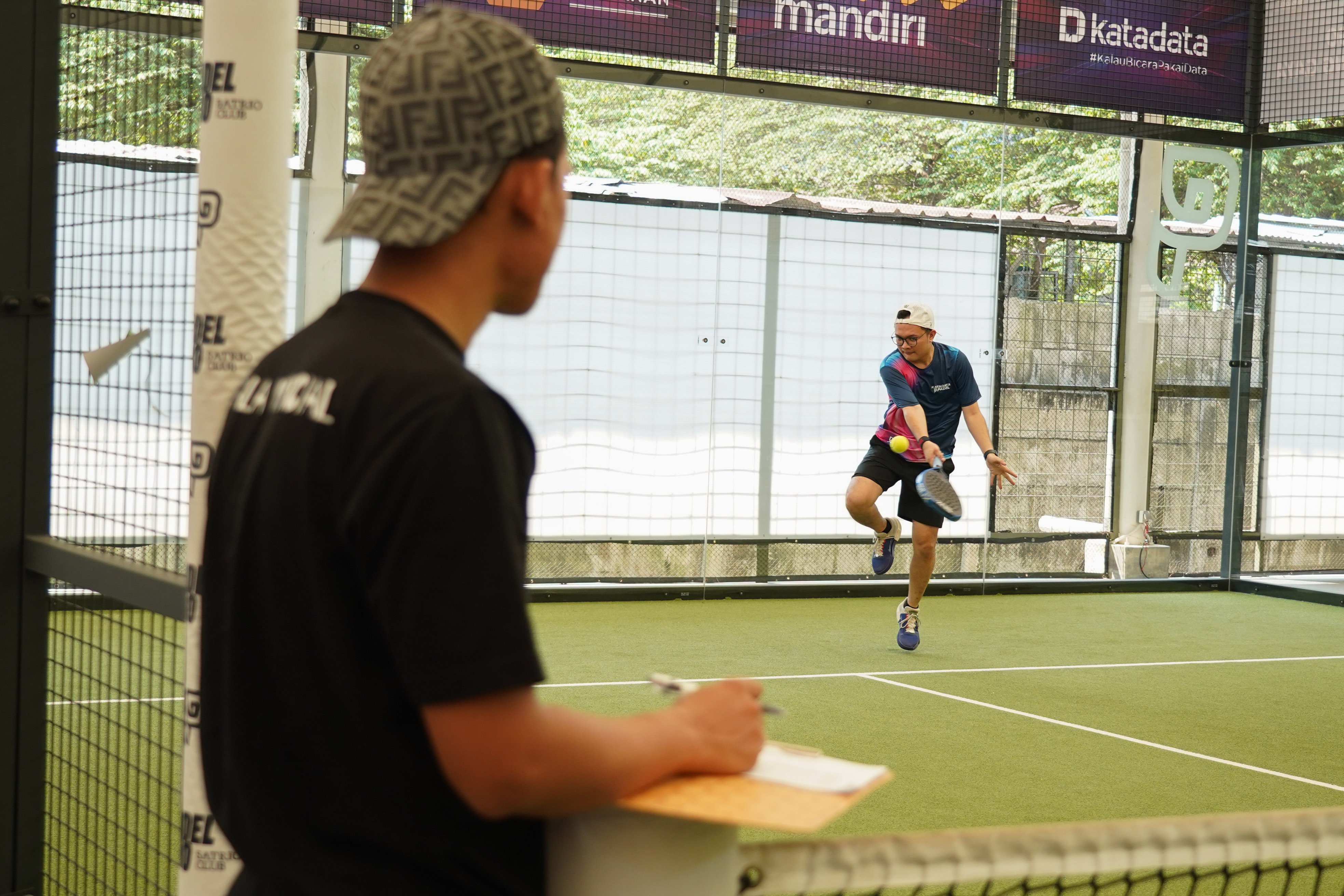 Pemain padel mengembalikan bola ke arah lawan saat bertanding pada Katadata Padel Tournament di Padel Pro Satrio Club, Jakarta, Sabtu (29/8/2026). Kompetisi ini diikuti 72 peserta dan mempertandingkan kategori Men\'s Doubles dan Women\'s Doubles dengan total hadiah Rp35 juta ini menjadi wadah bagi para profesional dari bidang kehumasan, media, dan korporasi untuk berkompetisi sekaligus membangun interaksi melalui olahraga. 