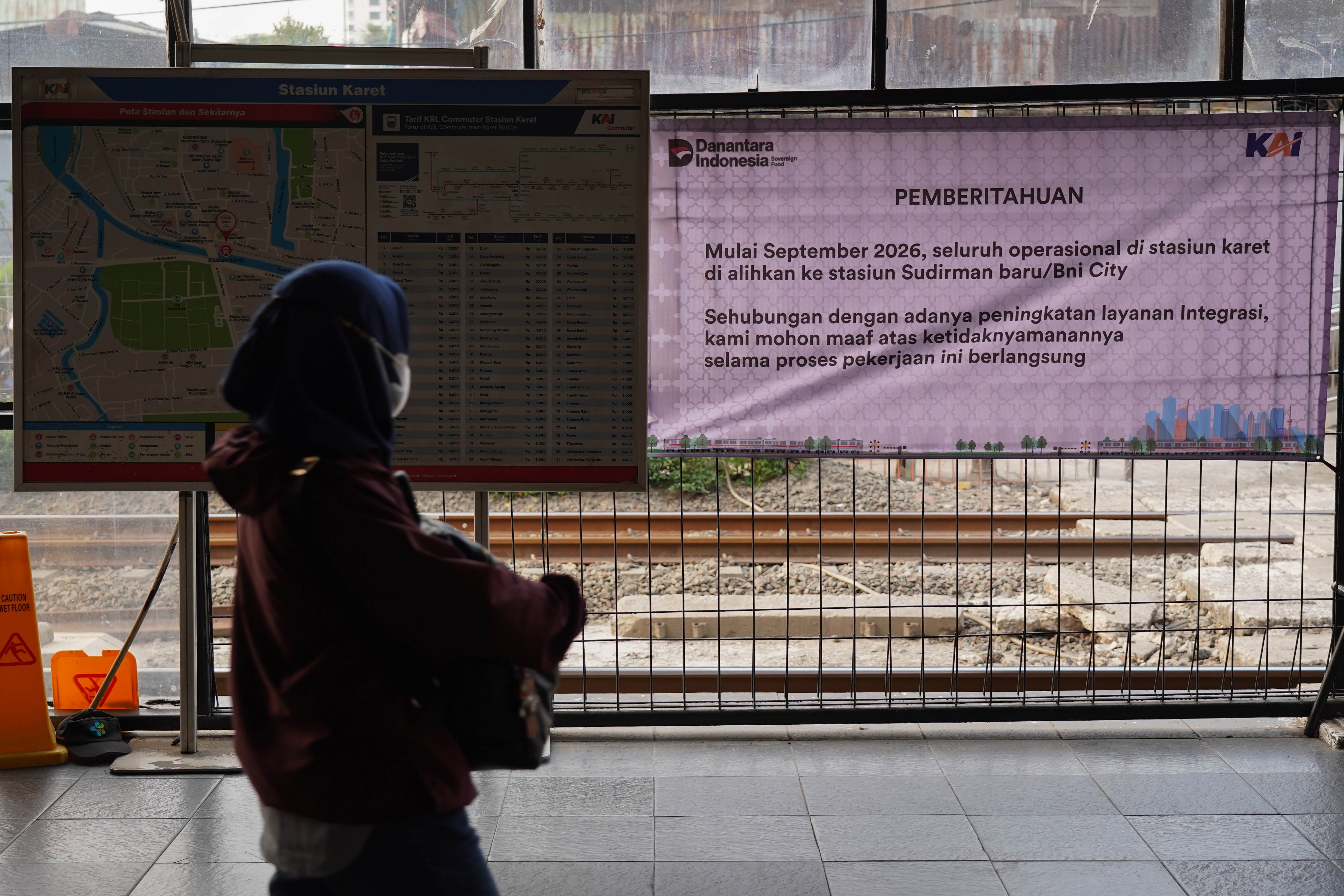 Penumpang melihat spanduk pengumuman yang berisi informasi pengalihan operasional KRL di Stasiun Karet, Jakarta, Senin (31/8/2026). PT Kereta Api Indonesia (KAI) mengalihkan operasional naik dan turunnya penumpang Commuter Line Jabodetabek di Stasiun Karet ke Stasiun BNI City mulai 1 September 2026 seiring dengan proses pengerjaan integrasi kedua stasiun tersebut.