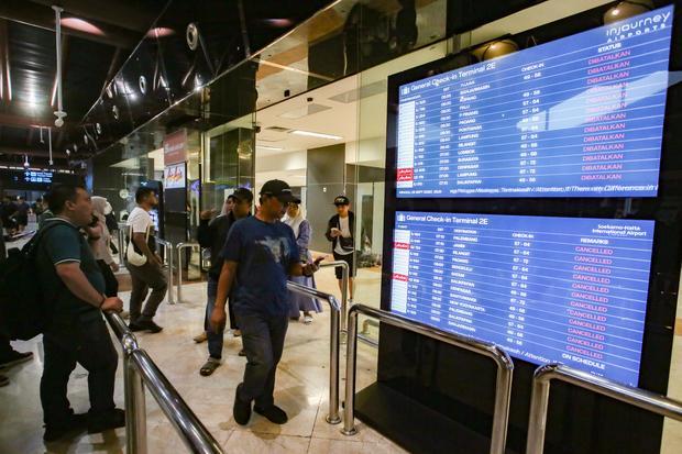 Calon penumpang melihat layar monitor jadwal penerbangan yang ada di Terminal 2 keberangkatan Bandara Soekarno Hatta, Tangerang, Banten, Minggu (6/9/2026). Berdasarkan Notice To Airmen atau NOTAM yang dikeluarkan AirNav Indonesia, Bandara Soekarno Hatta ditutup sementara untuk seluruh aktifitas penerbangan karena adanya indikasi sebaran abu vulkanik dari Gunung Anak Krakatau.