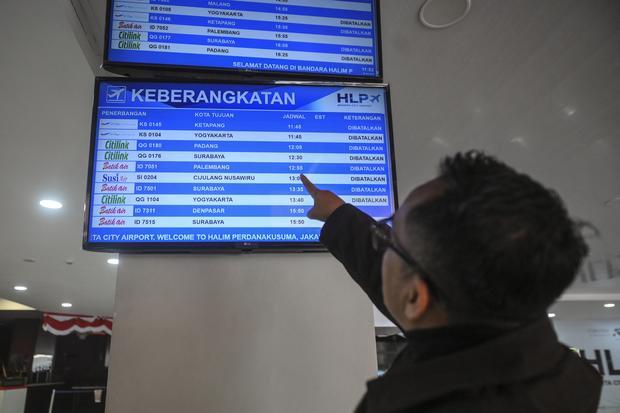Calon penumpang melihat layar informasi penerbangan di Bandara Halim Perdanakusuma, Jakarta, Minggu (6/9/2026). Bandara Halim Perdanakusuma menutup sementara aktivitas penerbangan akibat adanya sebaran abu vulkanik dari Gunung Anak Krakatau.