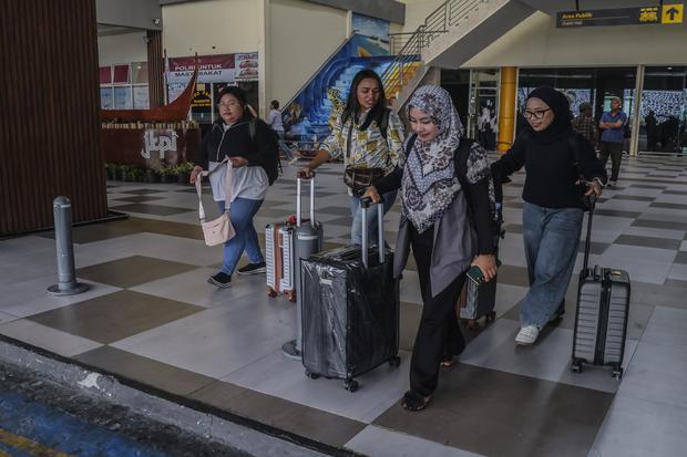 Calon penumpang tujuan Jakarta yang batal berangkat berjalan meninggalkan Bandara Sultan Babullah Ternate, Maluku Utara, Senin (7/9/2026). Penutupan sementara Bandara Soekarno-Hatta akibat sebaran abu vulkanik Gunung Anak Krakatau menyebabkan penerbangan rute Ternate-Jakarta yang dilayani Garuda Indonesia dan Batik Air tertunda pada Minggu (6/9) dan sebagian calon penumpang memilih penerbangan alternatif menuju Surabaya.