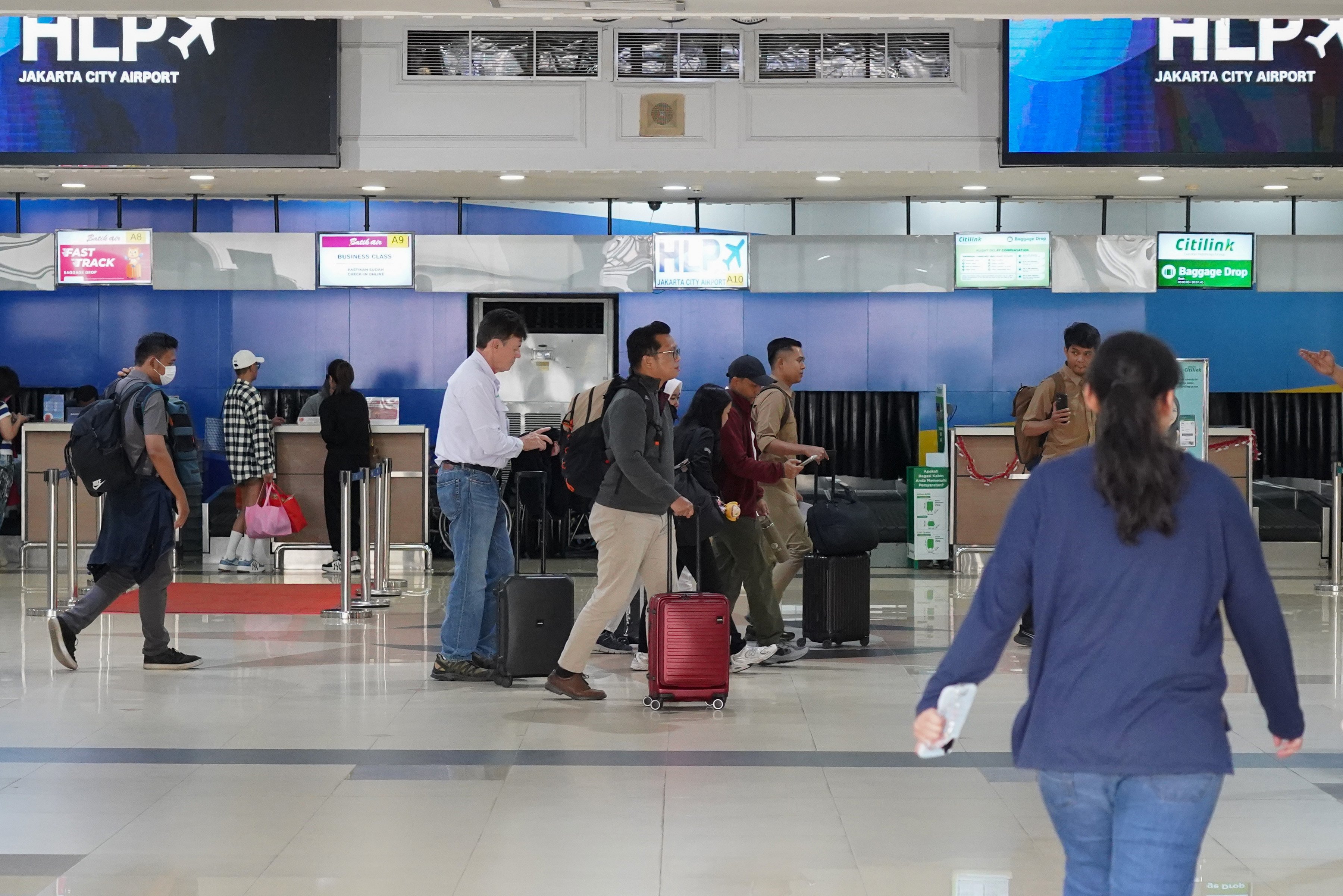Calon penumpang berjalan menuju ruang keberangkatan di Bandara Halim Perdanakusuma, Jakarta, Selasa (8/9/2026). Bandara Halim kembali melayani penerbangan untuk keberangkatan dan kedatangan penumpang setelah sempat ditutup sementara karena sebaran abu vulkanik erupsi Gunung Anak Krakatau.