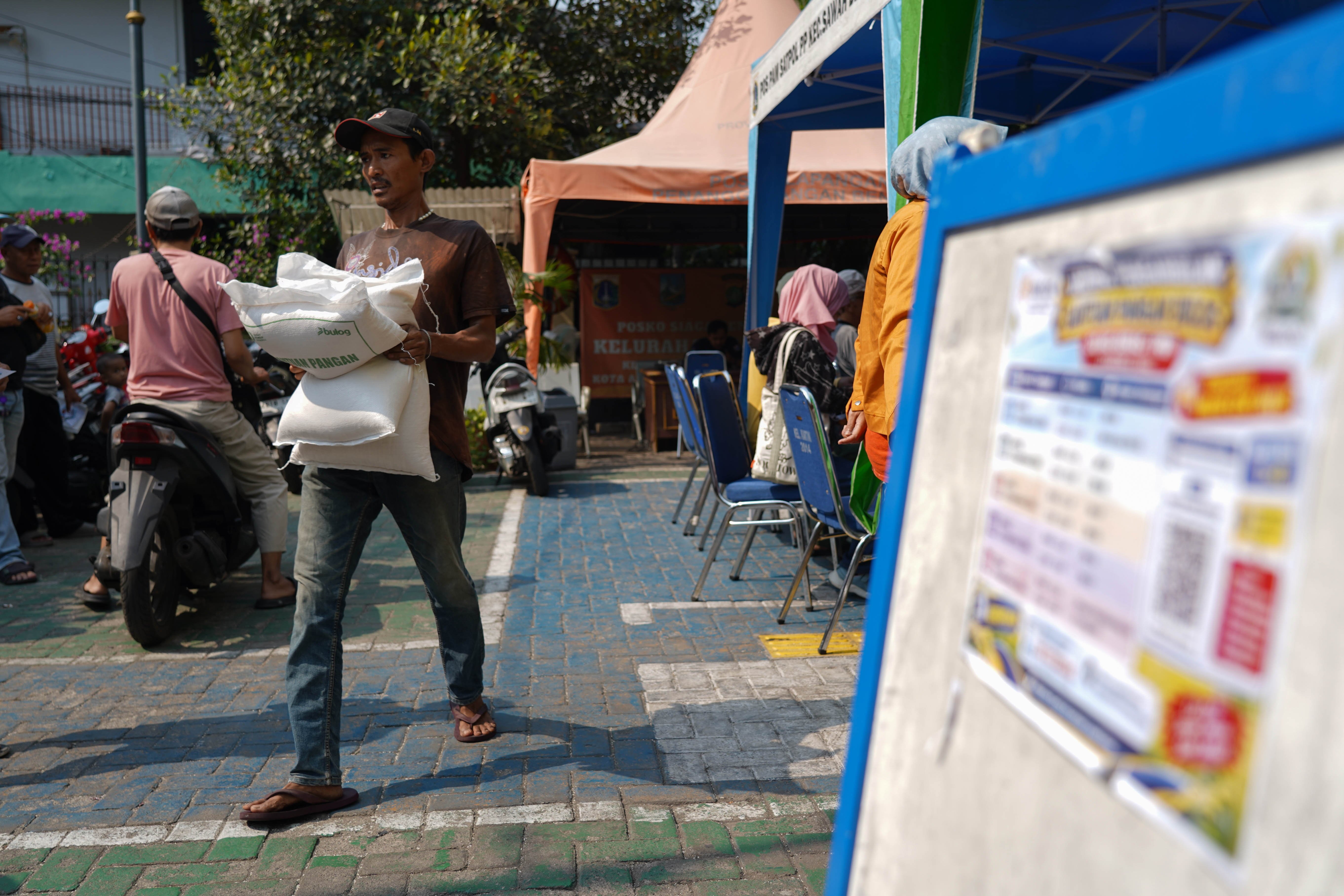 Warga Penerima Bantuan Pangan (PBP) membawa beras yang disalurkan di Kelurahan Kartini, Kecamatan Sawah Besar, Jakarta Pusat, Selasa (15/9/2026). Pemerintah memberikan Bantuan Pangan Beras yang menyasar sekitar 33,2 juta keluarga di kategori desil 1 hingga desil 4 dengan skema penyaluran secara rapel untuk alokasi tiga bulan sehingga penerima memperoleh total beras sebanyak 30 kilogram.