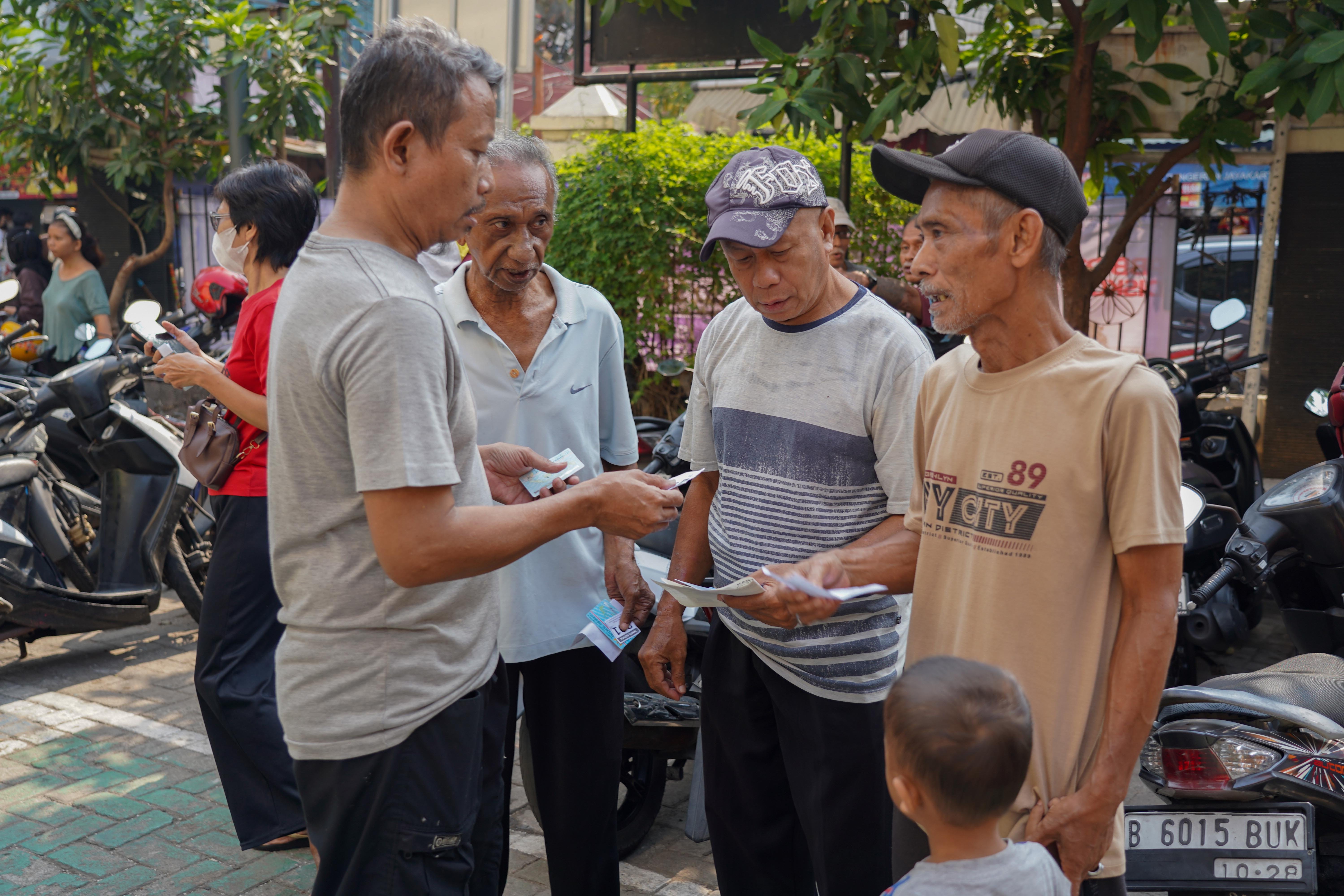 Warga Penerima Bantuan Pangan (PBP) mengecek dokumen kelengkapan saat penyaluran beras Kelurahan Kartini, Kecamatan Sawah Besar, Jakarta Pusat, Selasa (15/9/2026). Pemerintah memberikan Bantuan Pangan Beras yang menyasar sekitar 33,2 juta keluarga di kategori desil 1 hingga desil 4 dengan skema penyaluran secara rapel untuk alokasi tiga bulan sehingga penerima memperoleh total beras sebanyak 30 kilogram.