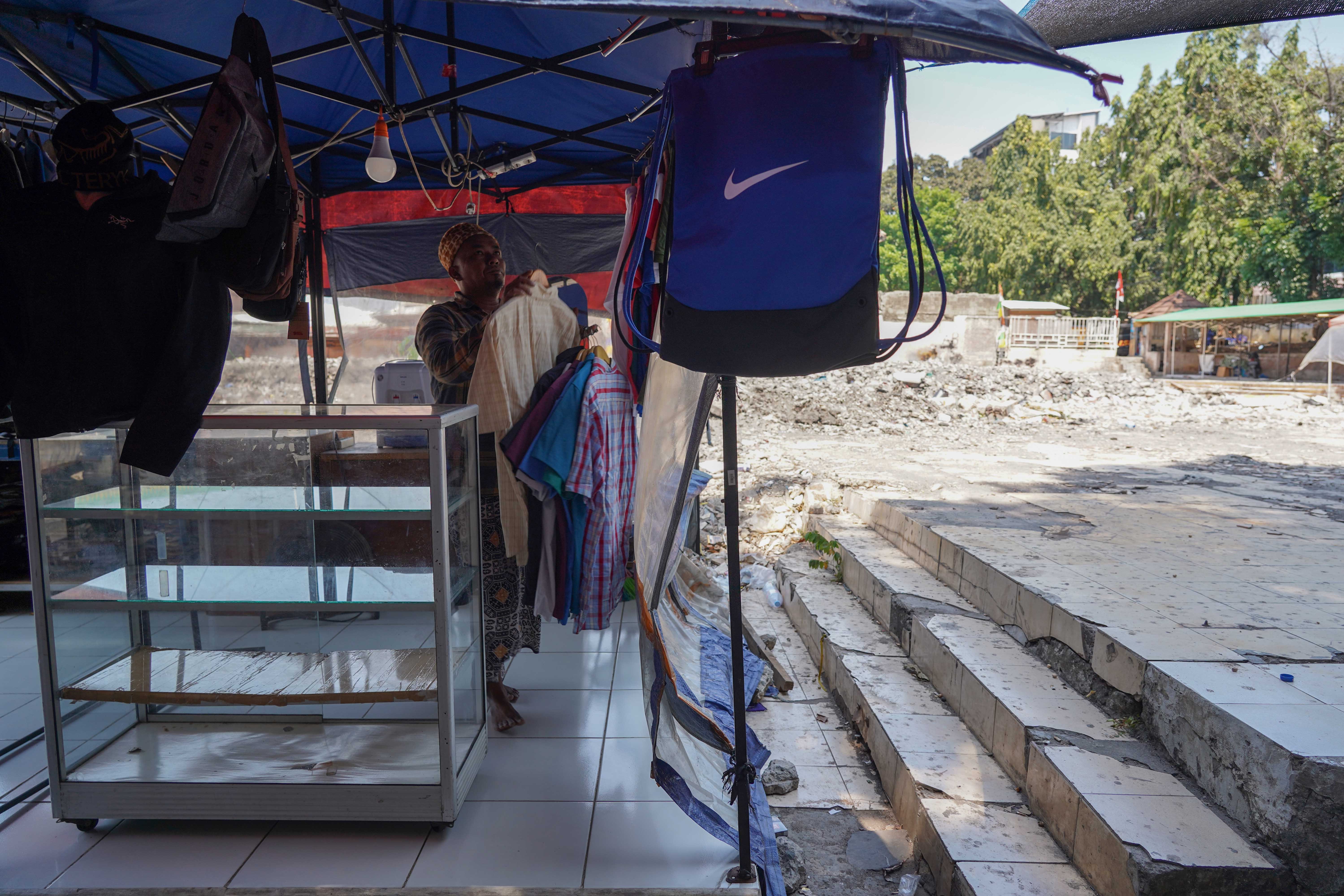Pedagang menata pakaian yang dijual di Pasar Taman Puring, Kebayoran Baru, Jakarta Selatan, Senin (14/9/2026). Setahun pascakebakaran yang melanda pasar tersebut pada 28 Juli 2025 dan menghanguskan 512 kios, para pedagang menagih janji Pemerintah Provinsi DKI Jakarta untuk merevitalisasi Pasar Taman Puring agar kegiatan jual beli dapat berlangsung seperti sedia kala.