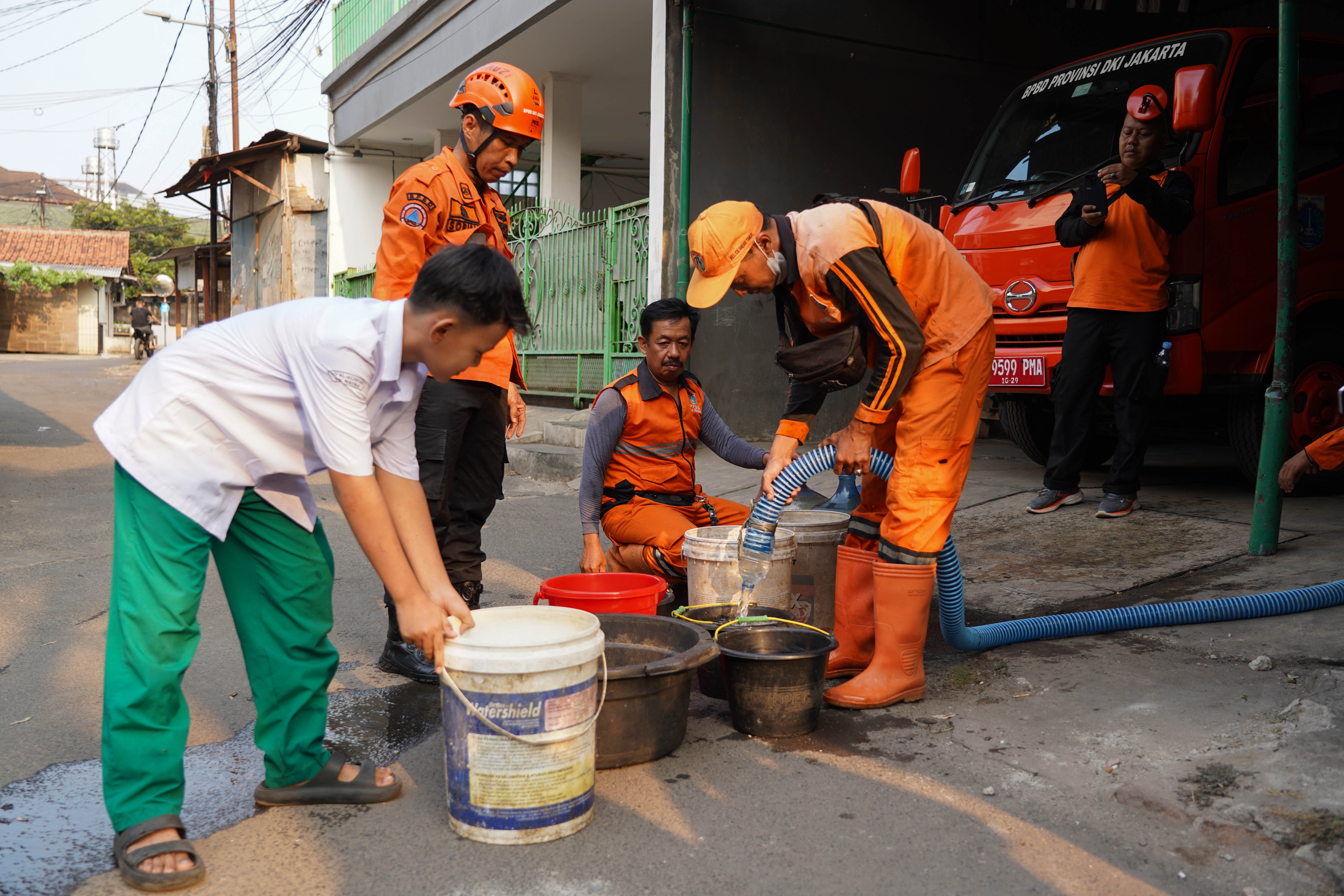 Personel Badan Penanggulangan Bencana Daerah (BPBD) mengisi air ke dalam ember milik warga yang terdampak kekeringan di Cilandak Timur, Jakarta Selatan, Senin (21/9/2026). BPBD Provinsi Jakarta menyalurkan bantuan air bersih sebanyak 5.000 liter kepada warga yang mengalami kesulitan air akibat musim kemarau.