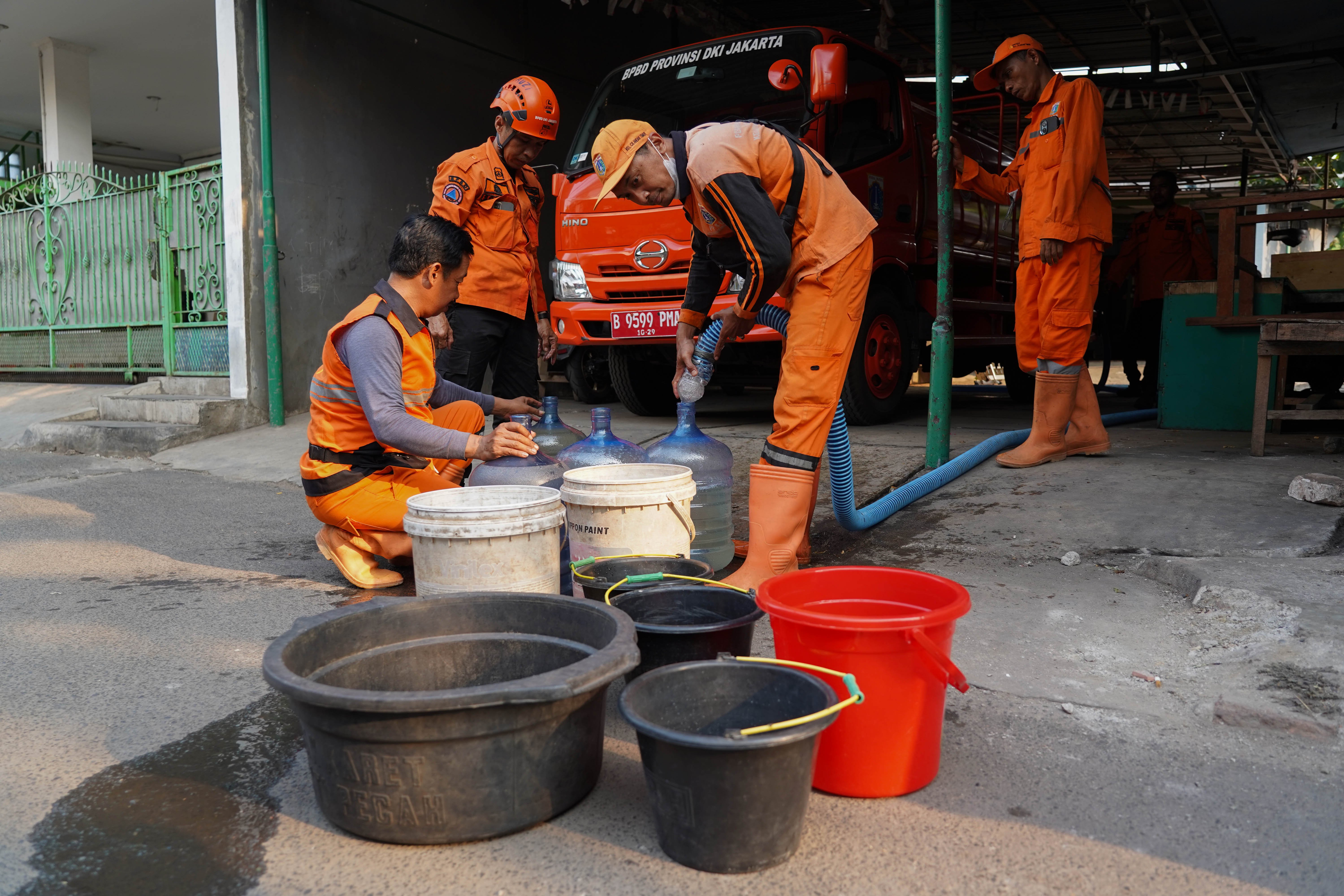 Personel Badan Penanggulangan Bencana Daerah (BPBD) mengisi air ke dalam ember milik warga yang terdampak kekeringan di Cilandak Timur, Jakarta Selatan, Senin (21/9/2026). BPBD Provinsi Jakarta menyalurkan bantuan air bersih sebanyak 5.000 liter kepada warga yang mengalami kesulitan air akibat musim kemarau.