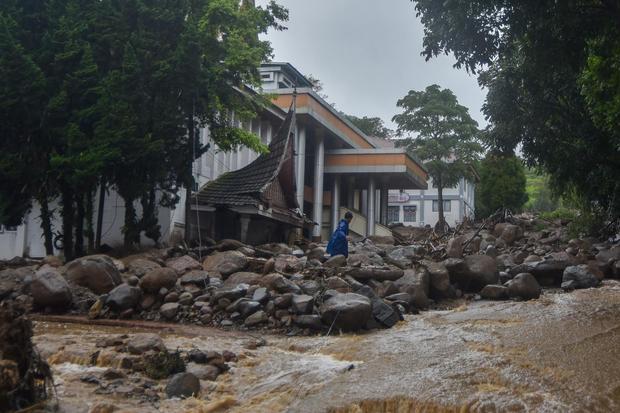 Warga berjalan melewati material banjir bandang di depan Kantor Bupati Solok, Arosuka, Kabupaten Solok, Sumatera Barat, Selasa (22/9/2026). Banjir bandang yang menerjang kawasan perkantoran di pusat kabupaten pada Senin (21/9) malam itu juga memutus akses jalan nasional dan menyebabkan sejumlah korban hilang.