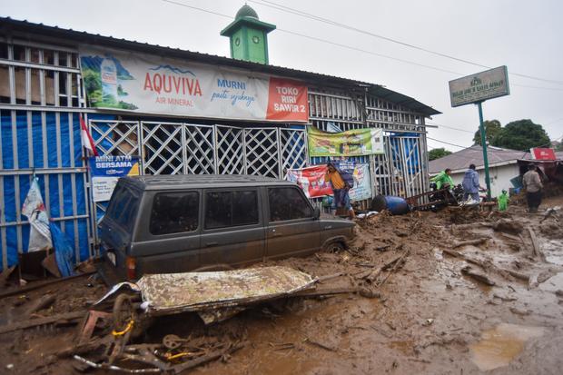 Warga mengecek kondisi kendaraan yang terendam material banjir bandang di Arosuka, Kabupaten Solok, Sumatera Barat, Selasa (22/9/2026). Banjir bandang yang menerjang kawasan perkantoran di pusat kabupaten pada Senin (21/9) malam itu juga memutus akses jalan nasional dan menyebabkan sejumlah korban hilang.