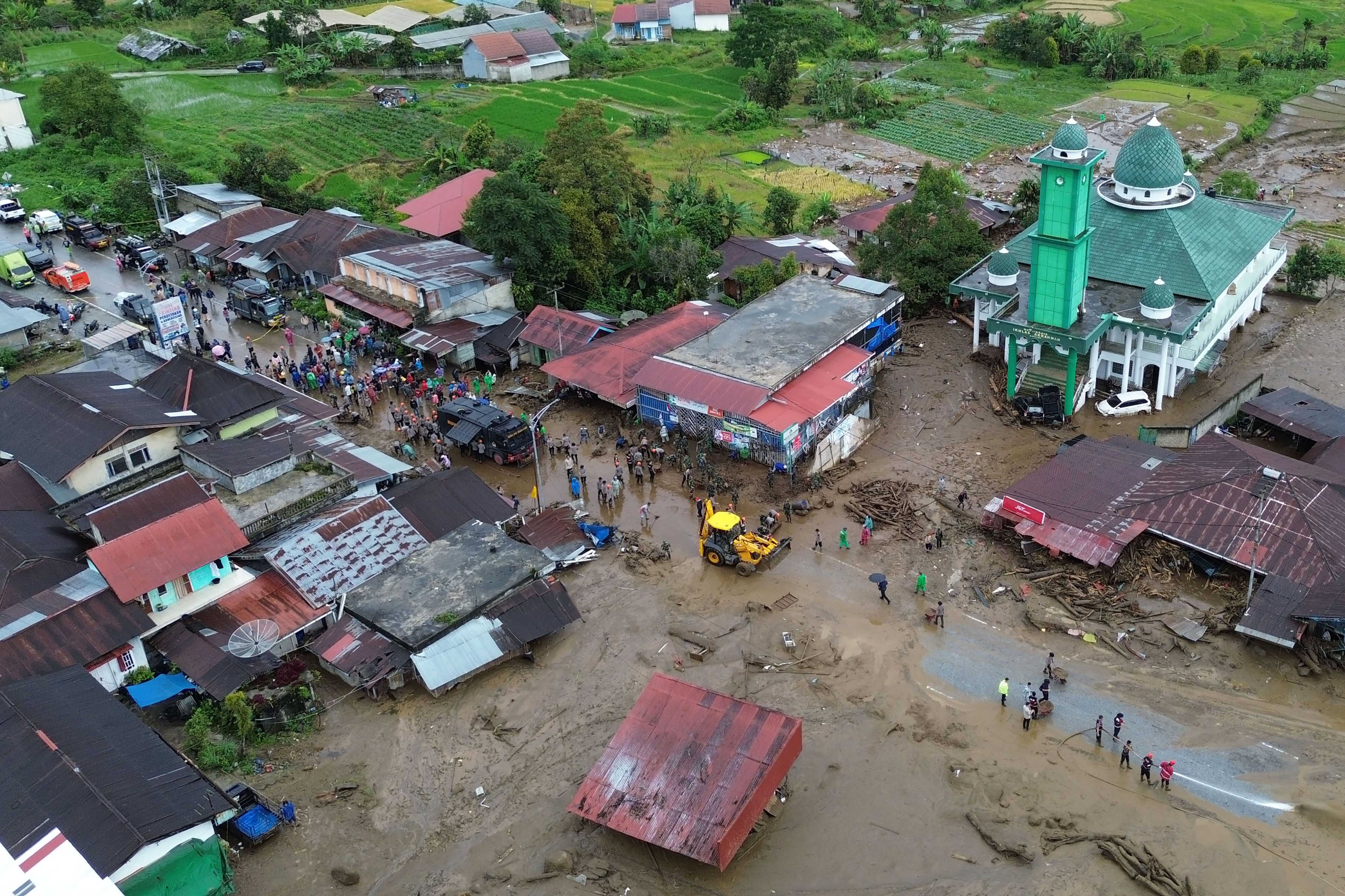 Foto udara alat berat membersihkan jalan akibat dampak banjir bandang menerjang kawasan Arosuka, Kabupaten Solok, Sumatera Barat, Selasa (22/9/2026). Berdasarkan data BPBD Solok, sebanyak 200 KK terdampak banjir bandang pada Senin (21/9) dengan empat korban luka-luka dan dua orang belum ditemukan sementara akses utama jalan nasional masih terputus. 