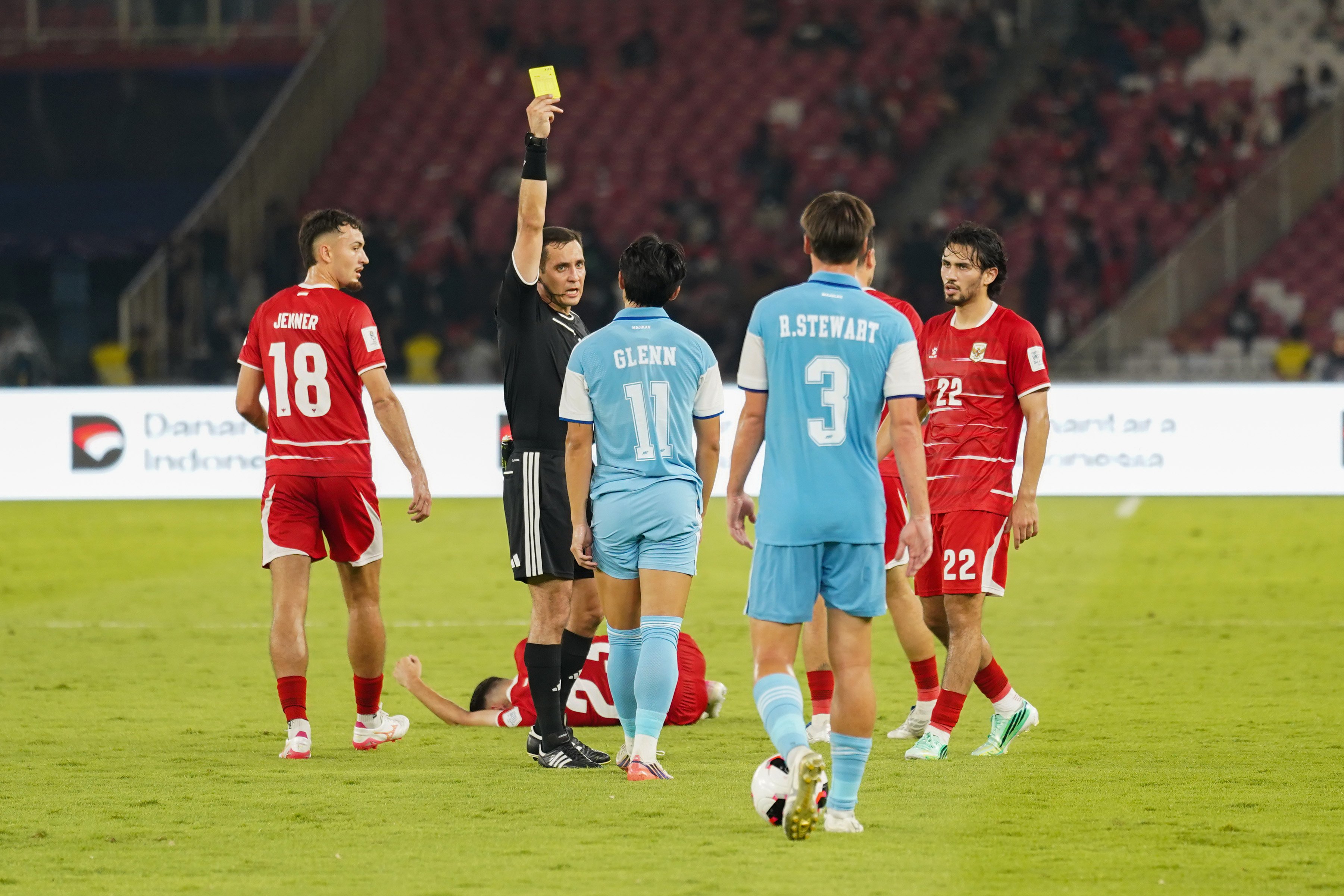 Wasit Rustam Lutfullin (kedua kiri) memberikan kartu kuning kepada pesepak bola Timnas Singapura Glenn Kweh (tengah) yang melanggar pesepak bola Timnas Indonesia saat bertanding pada FIFA ASEAN Cup 2026 di Stadion Utama Gelora Bung Karno, Jakarta, Jumat (25/9/2026). Pertandingan tersebut dimenangkan oleh Timnas Indonesia dengan skor 2-0 dengan golnya masing-masing dicetak oleh Ragnar Oratmangoen (13\') dan Ole Romeny (74\'). 