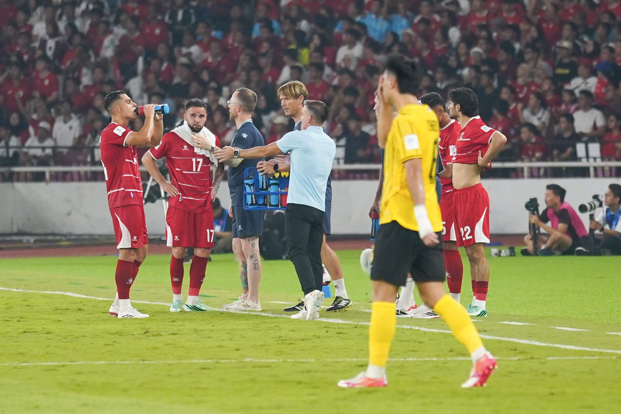 Pelatih Timnas Indonesia John Herdman (tengah) memberikan instruksi kepada Calvin Verdonk (kedua kiri) dan Joey Pelupessy (kiri) yang bertanding melawan Timnas Malaysia pada FIFA ASEAN Cup 2026 di Stadion Utama Gelora Bung Karno, Jakarta, Senin (28/9/2026). Pertandingan tersebut berakhir imbang dengan skor 0-0. 