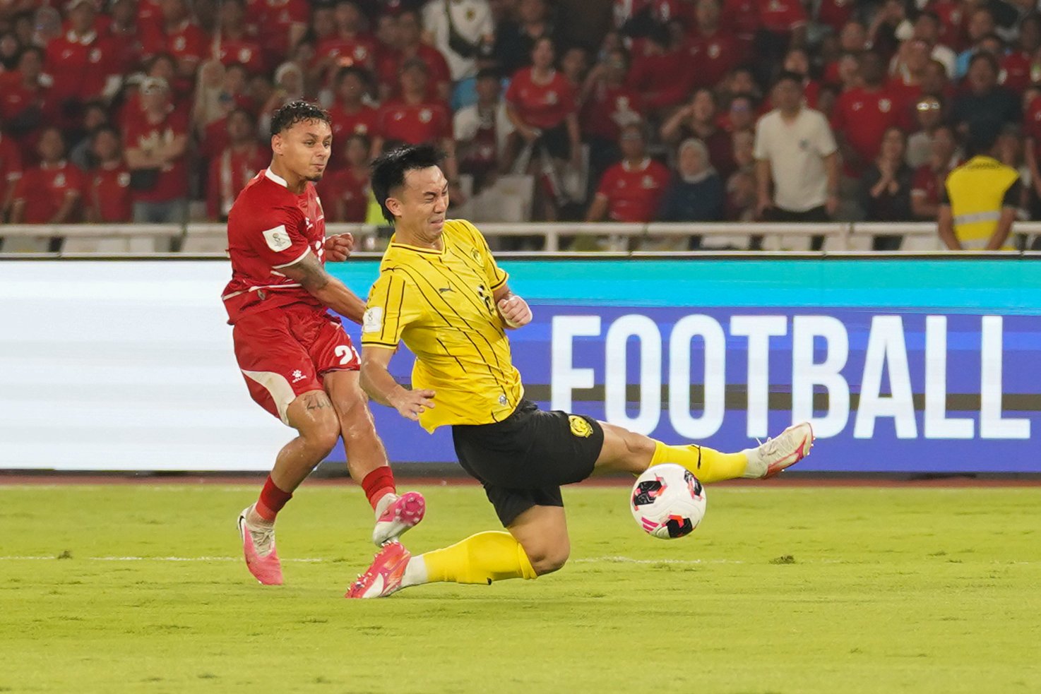 Pesepak bola Timnas Indonesia Dean James (kiri) menendang bola yang dihalau oleh pesepak bola Timnas Malaysia Quentin Cheng saat bertanding pada FIFA ASEAN Cup 2026 di Stadion Utama Gelora Bung Karno, Jakarta, Senin (28/9/2026). Pertandingan tersebut berakhir imbang dengan skor 0-0.