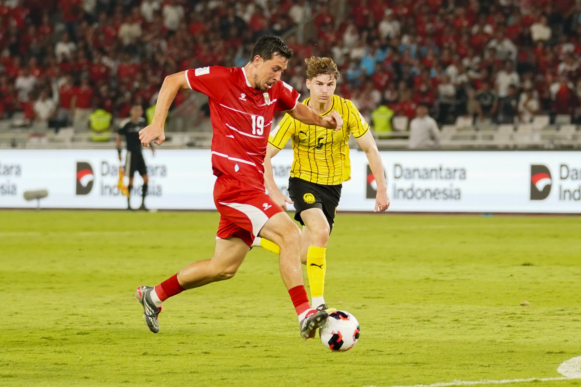 Pesepak bola Timnas Indonesia Thom Haye (kiri) membawa bola yang dikawal oleh pesepak bola Timnas Malaysia Brad Tapp saat bertanding pada FIFA ASEAN Cup 2026 di Stadion Utama Gelora Bung Karno, Jakarta, Senin (28/9/2026). Pertandingan tersebut berakhir imbang dengan skor 0-0.