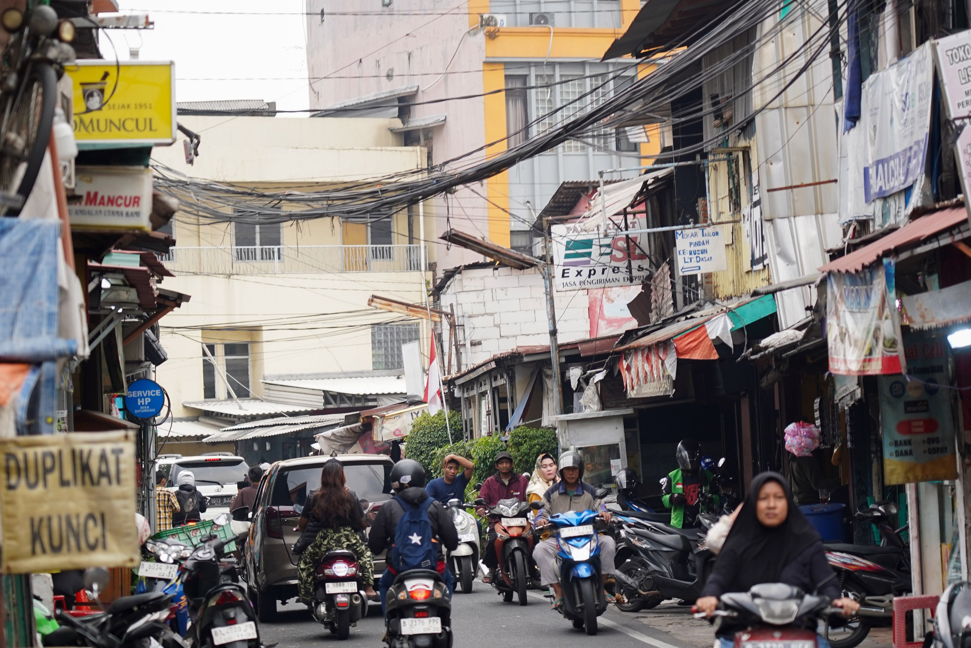 Pengendara sepeda motor melintas di dekat kabel yang semrawut di kawasan Jalan Lontar Raya, Kebon Kacang, Tanah Abang, Jakarta Pusat, Rabu (30/9/2026). Pemerintah Provinsi DKI Jakarta menargetkan seluruh kabel udara di Ibu Kota dapat diturunkan ke bawah tanah dalam lima tahun ke depan sebagai upaya memperbaiki wajah kota agar lebih rapi, aman dan nyaman bagi masyarakat.
