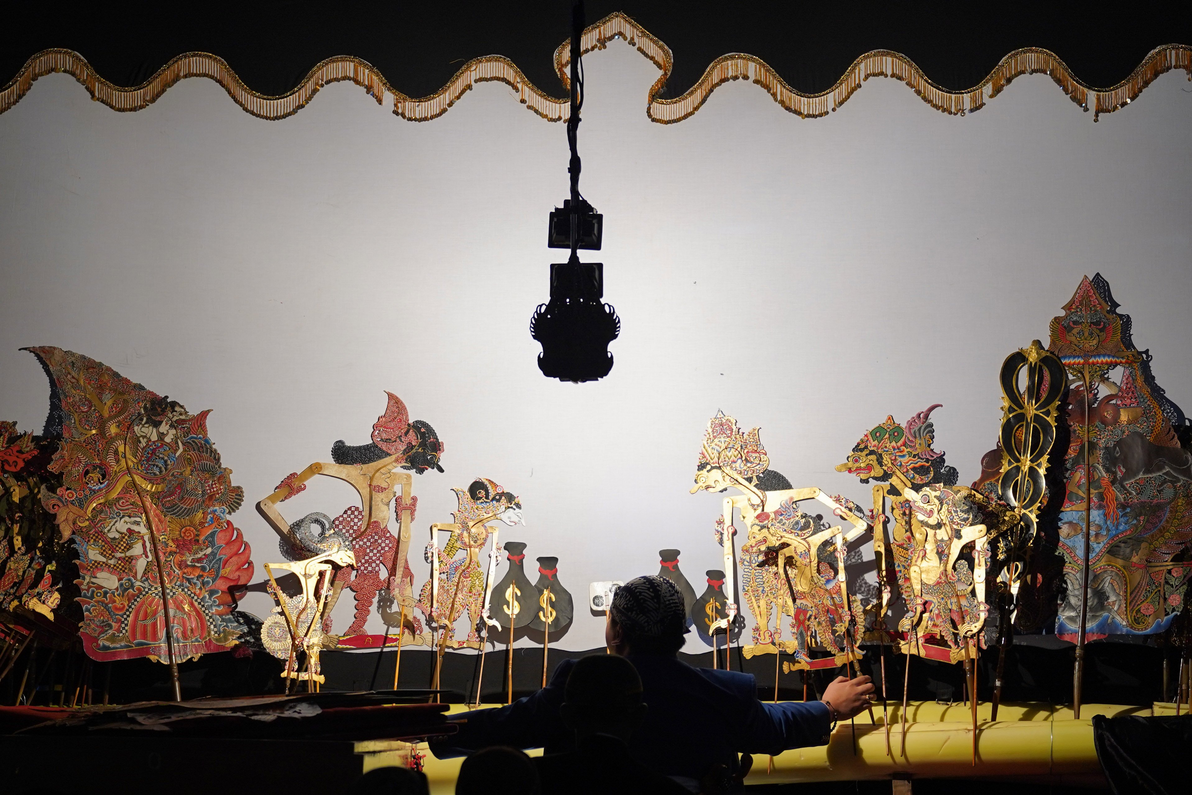 Dalang Ki Amar Pradopo memainkan wayang kulit saat pentas pada Katadata Financial Healing di Taman Literasi Martha Christina Tiahahu, Blok M, Jakarta Selatan, Sabtu (3/10/2026). Kegiatan yang merupakan rangkaian acara Bulan Inklusi Keuangan 2026 ini membahas tentang cara mengelola keuangan secara bijak di tengah pesatnya digitalisasi yang dikemas melalui diskusi, budaya, dan hiburan.