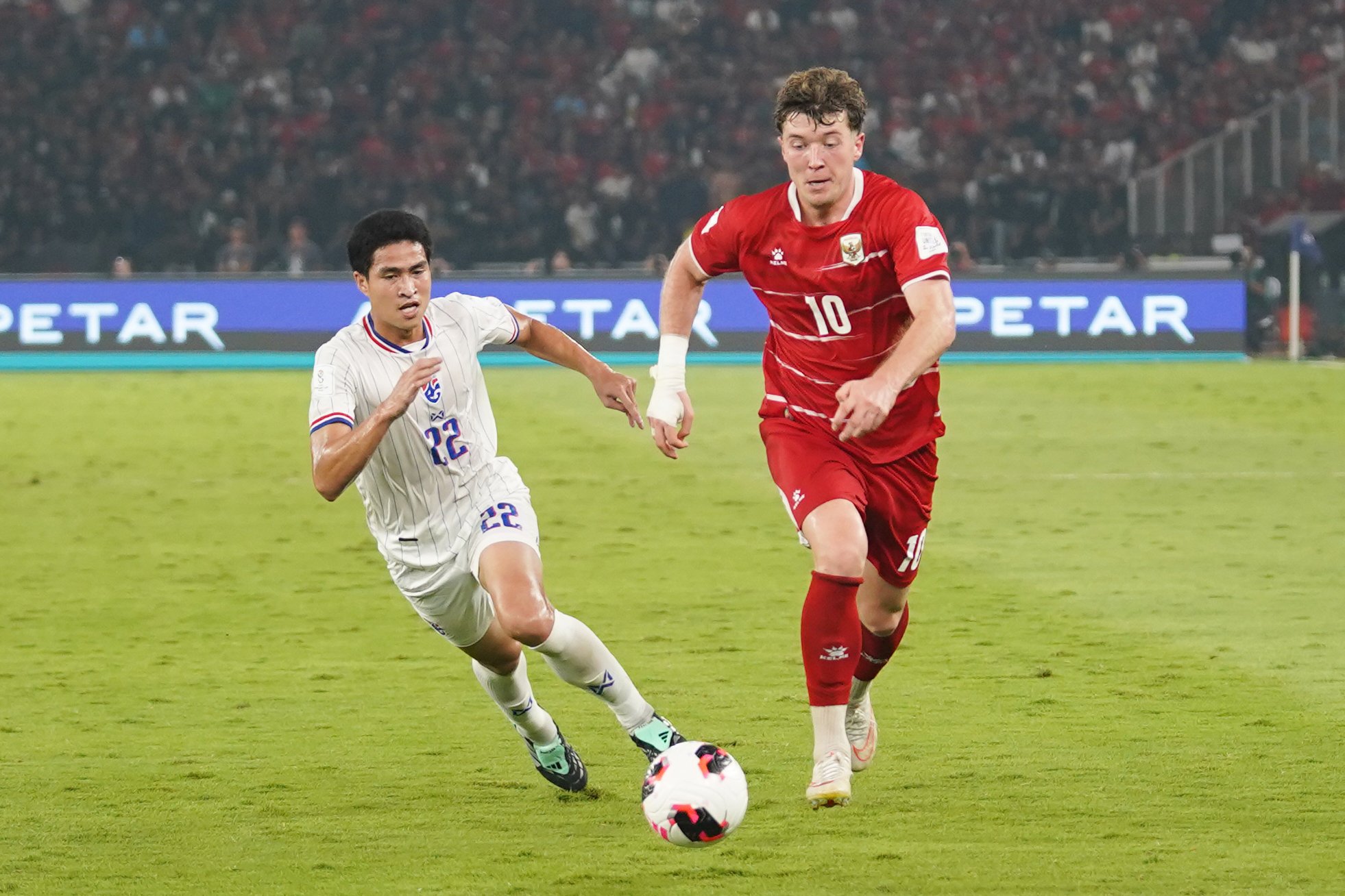 Pesepak bola Timnas Indonesia Ole Romeny (kanan) membawa bola yang dikawal oleh pesepak bola Timnas Thailand Seksan Ratree saat bertanding pada babak final FIFA ASEAN Cup 2026 di Stadion Utama Gelora Bung Karno, Jakarta, Senin (5/10/2026). Pertandingan tersebut dimenangkan oleh Timnas Indonesia lewat babak adu penalti dengan skor 4-2 dan memastikan skuad asuhan Pelatih John Herdman keluar sebagai juara.