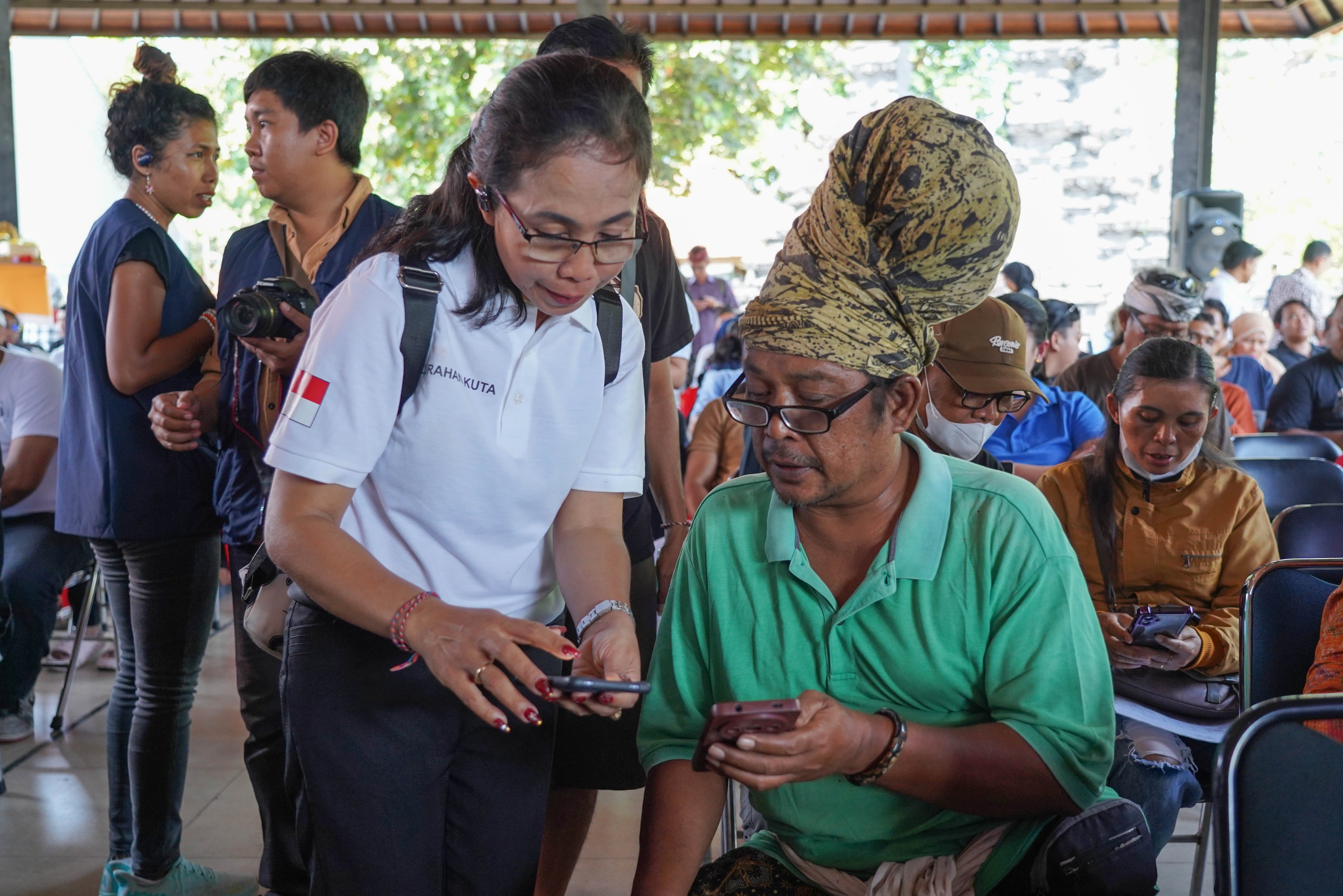 Petugas melayani warga yang hendak mendaftar Program Perlindungan Sosial (Perlinsos) Digital di Pura Dalem Kahyangan, Legian, Kabupaten Badung, Bali, Jumat (9/10/2026). Berdasarkan data Kementerian Komunikasi dan Digital hingga minggu pertama bulan Oktober 2026 sebanyak 625.858 kepala keluarga (KK) di Bali atau 50,52 persen dari keseluruhan KK di provinsi ini telah teregistrasi melalui portal perlinsos.