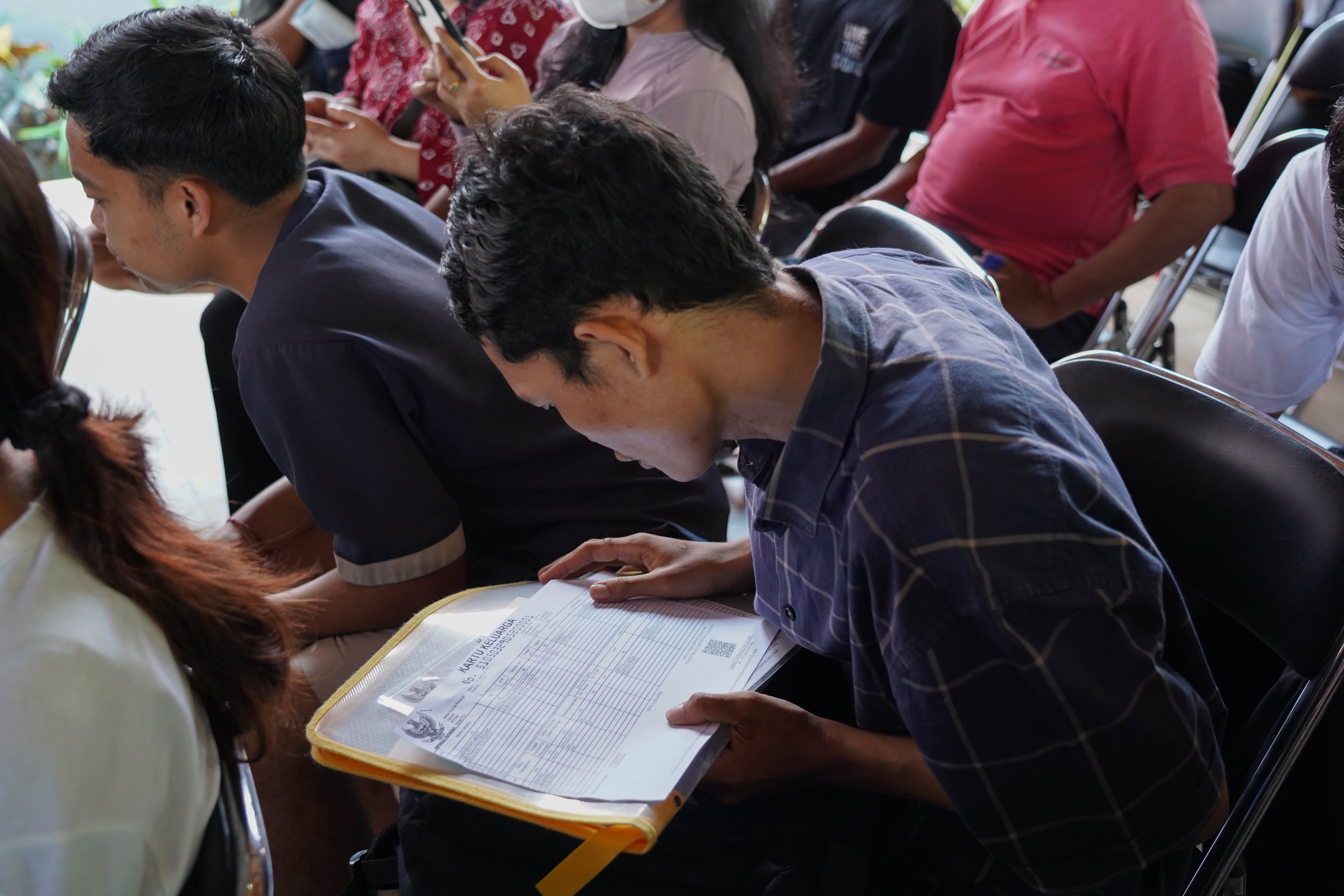 Warga menyiapkan dokumen saat hendak mendaftar Program Perlindungan Sosial (Perlinsos) Digital di Pura Dalem Kahyangan, Legian, Kabupaten Badung, Bali, Jumat (9/10/2026). Berdasarkan data Kementerian Komunikasi dan Digital hingga minggu pertama bulan Oktober 2026 sebanyak 625.858 kepala keluarga (KK) di Bali atau 50,52 persen dari keseluruhan KK di provinsi ini telah teregistrasi melalui portal perlinsos.