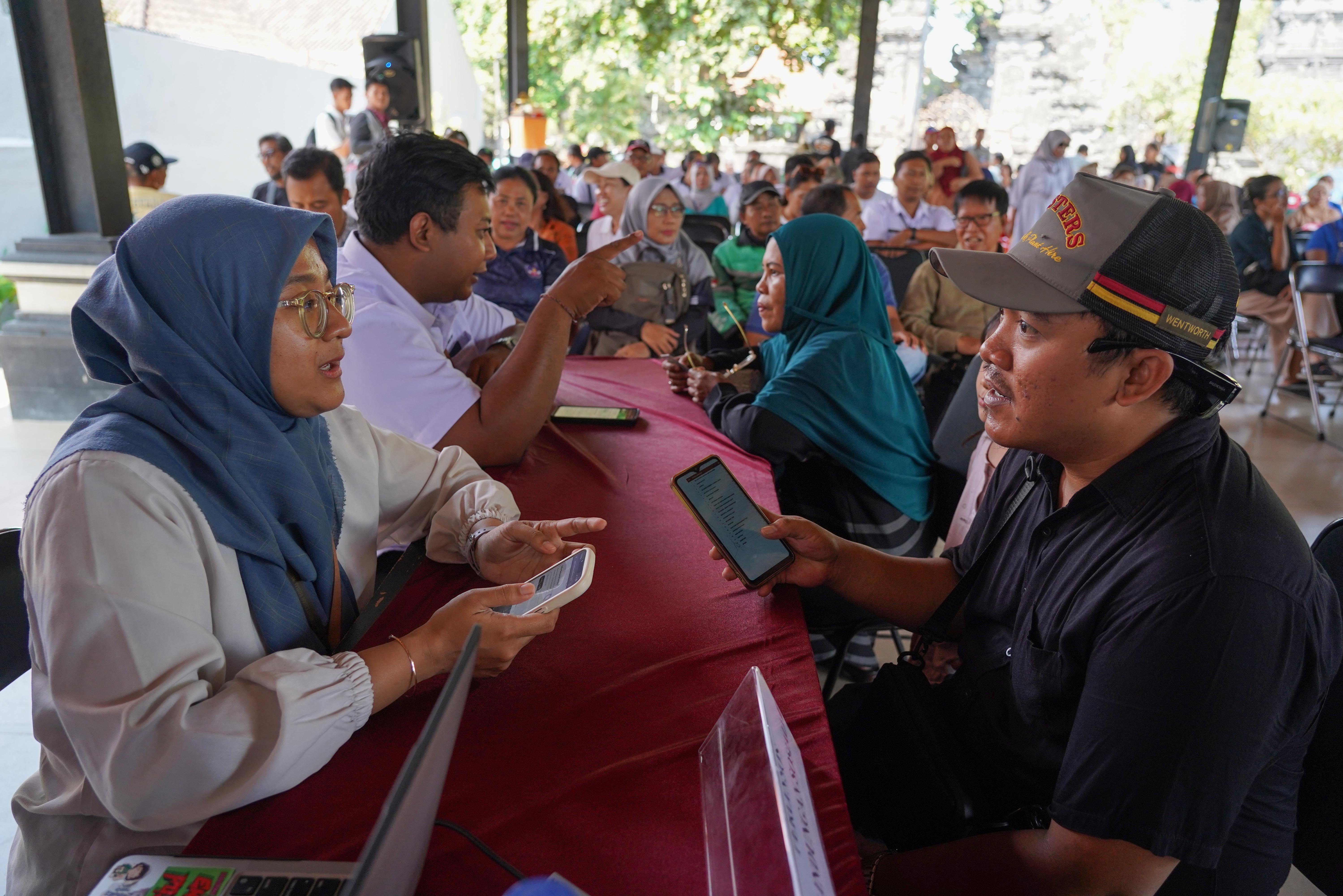 Petugas melayani warga yang hendak mendaftar Program Perlindungan Sosial (Perlinsos) Digital di Pura Dalem Kahyangan, Legian, Kabupaten Badung, Bali, Jumat (9/10/2026). Berdasarkan data Kementerian Komunikasi dan Digital hingga minggu pertama bulan Oktober 2026 sebanyak 625.858 kepala keluarga (KK) di Bali atau 50,52 persen dari keseluruhan KK di provinsi ini telah teregistrasi melalui portal perlinsos.