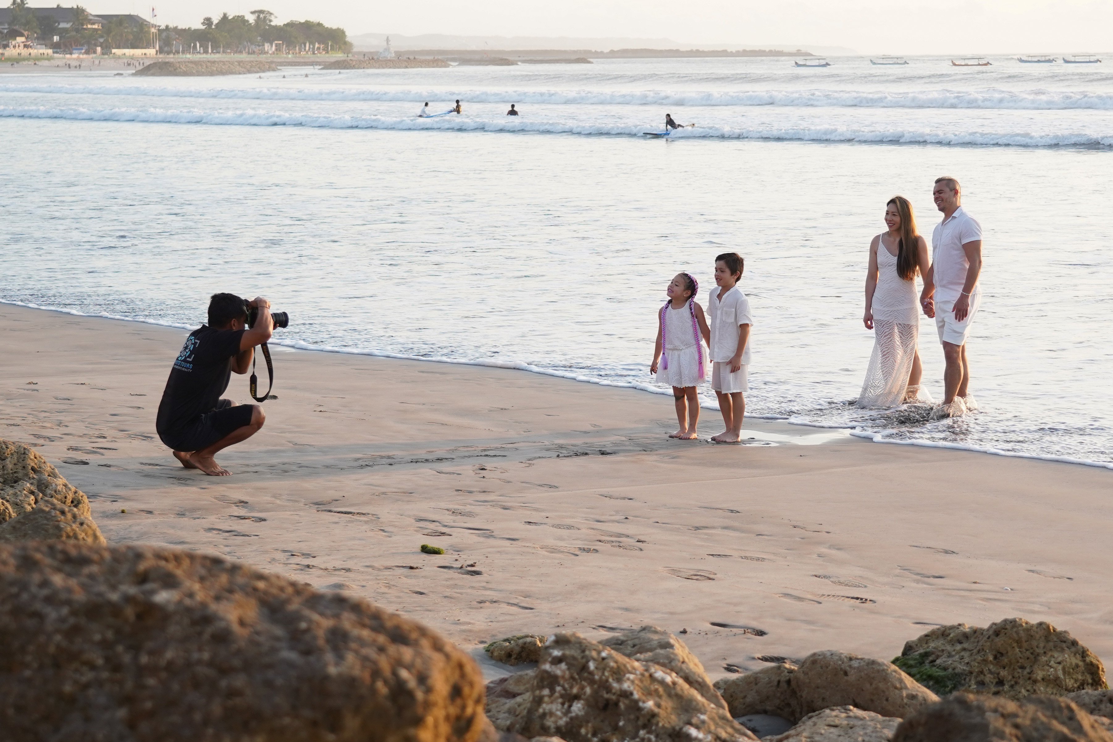 Fotografer memotret wisatawan yang berkunjung ke Pantai Kuta di Kabupaten Badung, Bali, Kamis (8/10/2026). Pantai yang memiliki luas sekitar 2,5 kilometer ini dikenal sebagai salah satu destinasi wisata di Pulau Dewata yang menawarkan pesona keindahan mulai dari hamparan pasir putih, ombak yang ideal untuk berselancar hingga pemandangan sunset yang memukau.