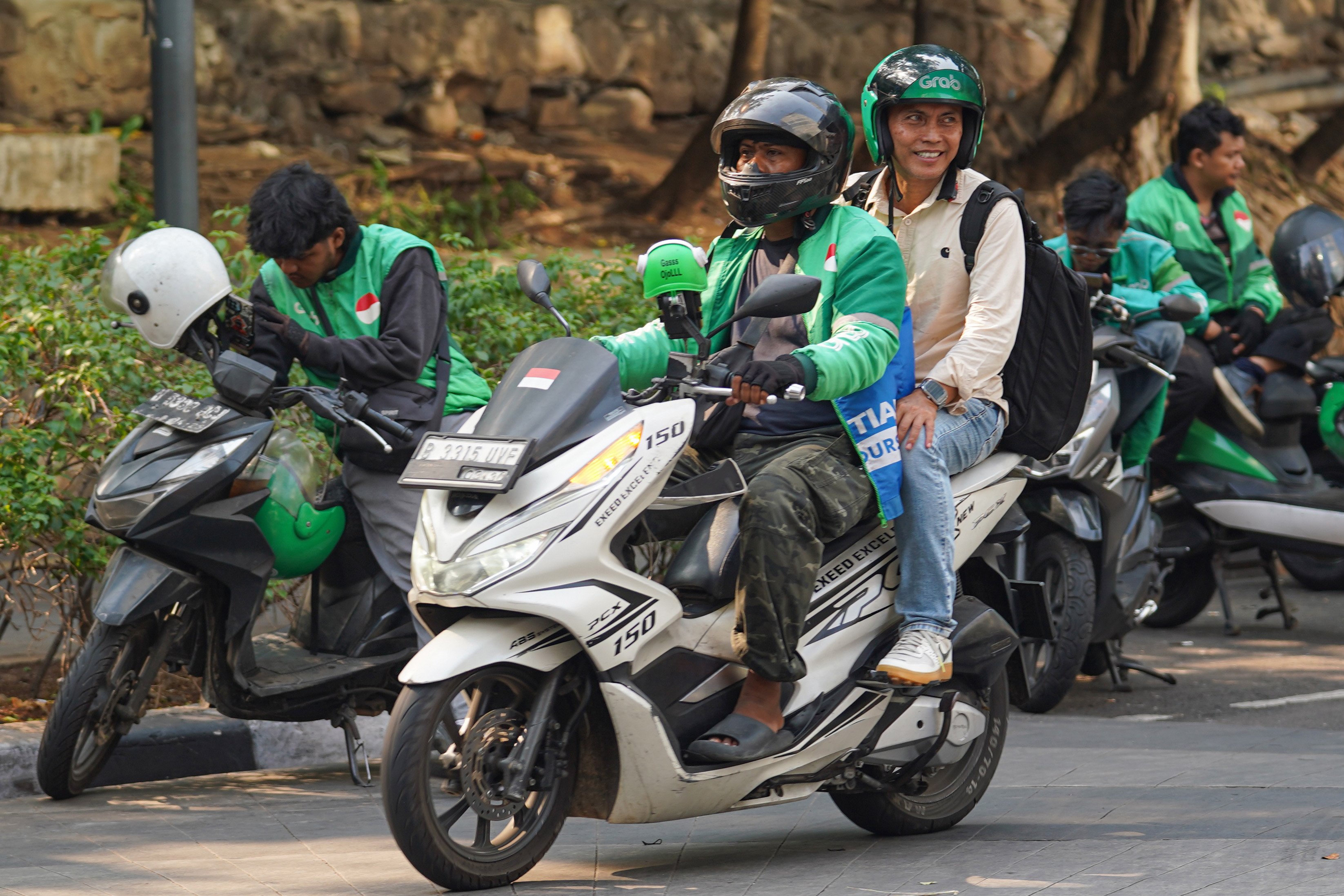 Pengemudi ojek online atau ojol mengantarkan penumpang di kawasan Dukuh Atas, Jakarta, Selasa (13/10/2026). Pemerintah resmi merilis Peraturan Presiden Nomor 27 Tahun 2026 tentang Perlindungan Ekosistem Transportasi Berbasis Platform Digital atau Perpres Ojol yang berisi tentang berbagai aspek terkait transportasi digital, mulai dari sistem elektronik, kemitraan, jaminan sosial, ketenagakerjaan, serta aturan-aturan untuk penerbitan peraturan pelaksanaan.