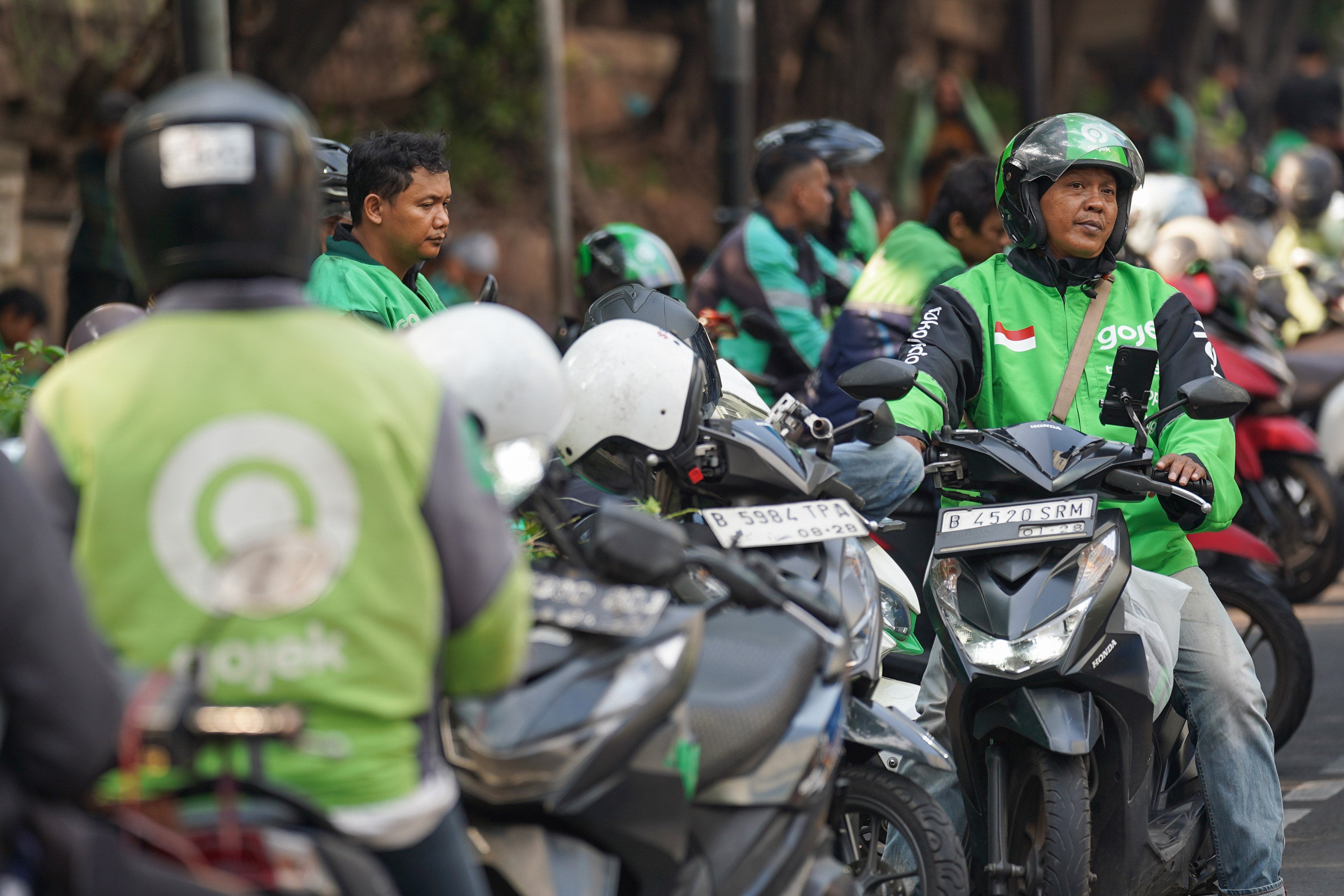 Pengemudi ojek online atau ojol menunggu pesanan di kawasan Dukuh Atas, Jakarta, Selasa (13/10/2026). Pemerintah resmi merilis Peraturan Presiden Nomor 27 Tahun 2026 tentang Perlindungan Ekosistem Transportasi Berbasis Platform Digital atau Perpres Ojol yang berisi tentang berbagai aspek terkait transportasi digital, mulai dari sistem elektronik, kemitraan, jaminan sosial, ketenagakerjaan, serta aturan-aturan untuk penerbitan peraturan pelaksanaan.