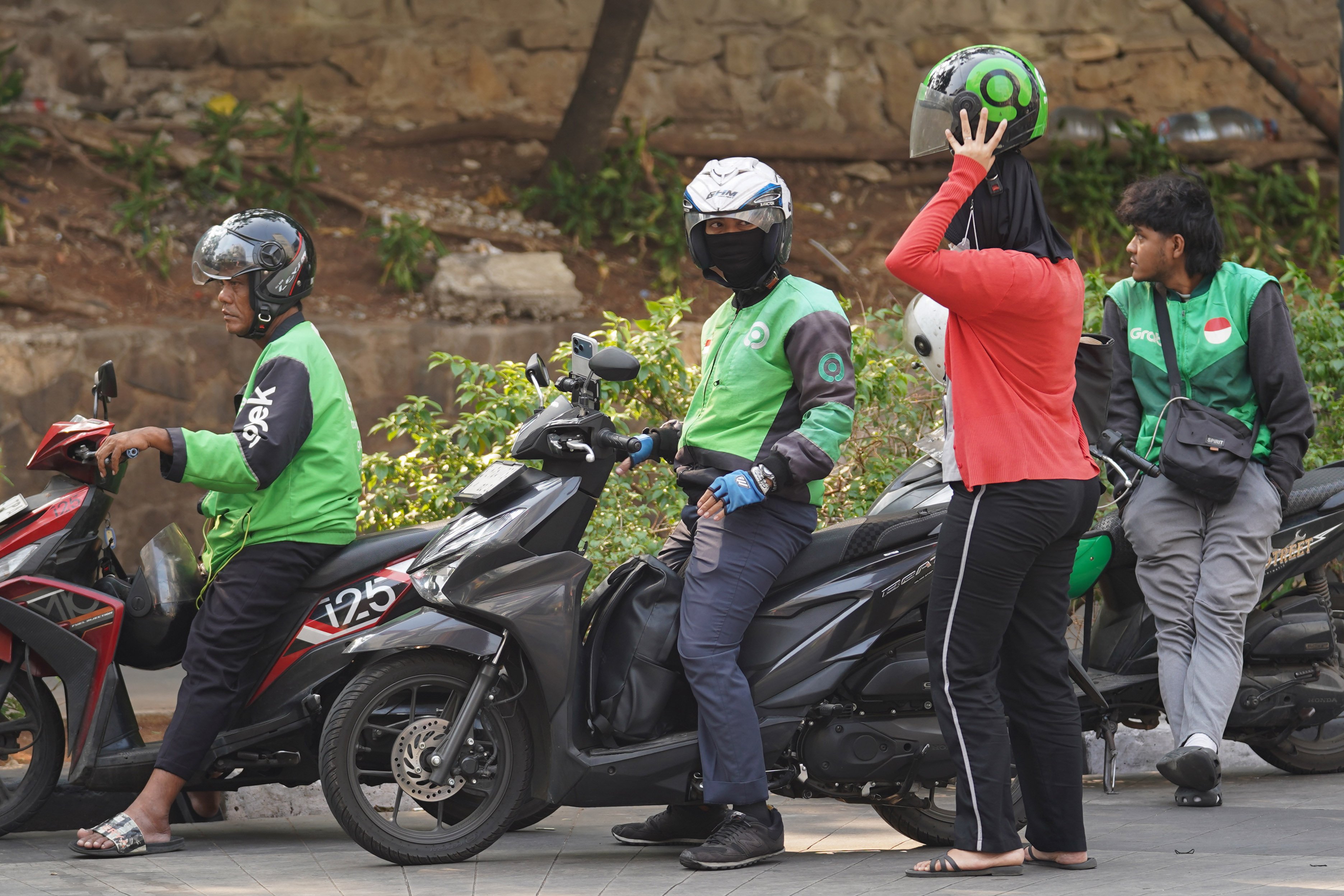 Pengemudi ojek online atau ojol mengantarkan penumpang di kawasan Dukuh Atas, Jakarta, Selasa (13/10/2026). Pemerintah resmi merilis Peraturan Presiden Nomor 27 Tahun 2026 tentang Perlindungan Ekosistem Transportasi Berbasis Platform Digital atau Perpres Ojol yang berisi tentang berbagai aspek terkait transportasi digital, mulai dari sistem elektronik, kemitraan, jaminan sosial, ketenagakerjaan, serta aturan-aturan untuk penerbitan peraturan pelaksanaan.