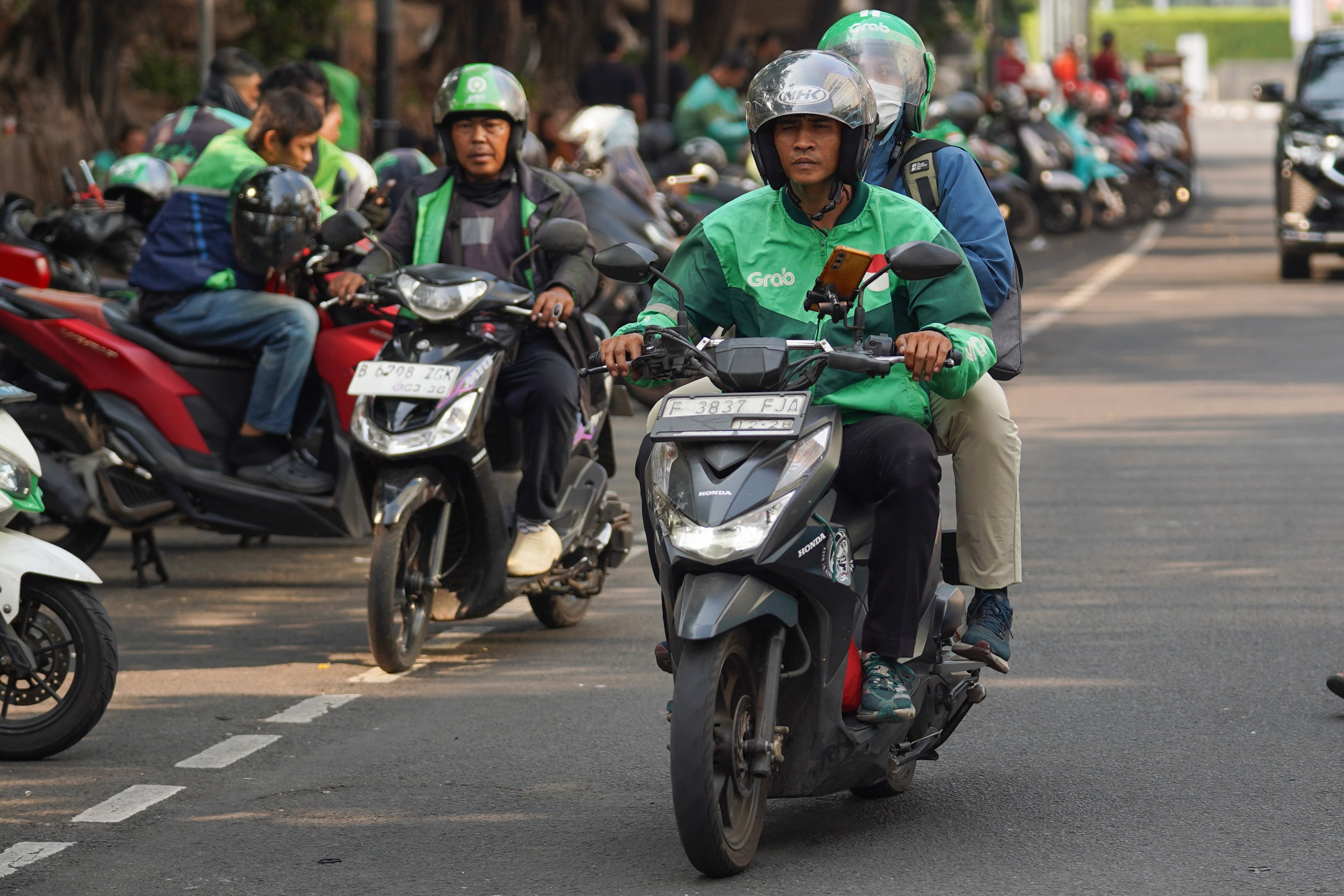 Pengemudi ojek online atau ojol mengantarkan penumpang di kawasan Dukuh Atas, Jakarta, Selasa (13/10/2026). Pemerintah resmi merilis Peraturan Presiden Nomor 27 Tahun 2026 tentang Perlindungan Ekosistem Transportasi Berbasis Platform Digital atau Perpres Ojol yang berisi tentang berbagai aspek terkait transportasi digital, mulai dari sistem elektronik, kemitraan, jaminan sosial, ketenagakerjaan, serta aturan-aturan untuk penerbitan peraturan pelaksanaan.