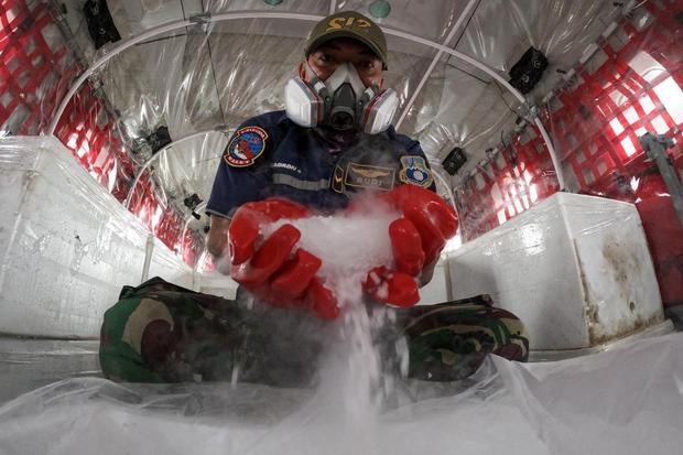 Prajurit TNI AU menunjukkan dry ice atau es kering sebagai bahan semai untuk Operasi Modifikasi Cuaca (OMC) di dalam pesawat Cassa C-212 milik Skadron IV Wing Udara 1.2 Grup 1 Angkut Lanud Abdulrachman Saleh di Base Ops Lanud Sri Mulyono Herlambang (SMH), Palembang, Sumatera Selatan, Senin (19/10/2026). Kementerian Kehutanan (Kemenhut) bersama BMKG serta TNI menggelar OMC menggunakan es kering untuk membantu mengurai asap akibat kebakaran hutan dan lahan.