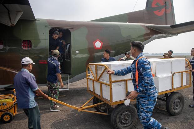 Prajurit TNI AU dibantu pekerja memindahkan boks berisi dry ice atau es kering sebagai bahan semai untuk Operasi Modifikasi Cuaca (OMC) ke dalam pesawat Cassa C-212 milik Skadron IV Wing Udara 1.2 Grup 1 Angkut Lanud Abdulrachman Saleh di Base Ops Lanud Sri Mulyono Herlambang (SMH), Palembang, Sumatera Selatan, Senin (19/10/2026). Kementerian Kehutanan (Kemenhut) bersama BMKG serta TNI menggelar OMC menggunakan es kering untuk membantu mengurai asap akibat kebakaran hutan dan lahan.