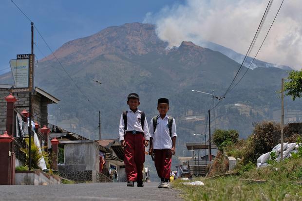 Dua orang pelajar berjalan dengan latar belakang kebakaran hutan di Gunung Sumbing wilayah Garung, Kalikajar, Wonosobo, Jawa Tengah, Selasa (20/10/2026). BPBD setempat menyatakan kebakaran hutan di Gunung Sumbing diketahui pada Senin (19/10/2026) sekitar pukul 15.00 WIB dan terus meluas hingga mendekati wilayah Temanggung akibat sulitnya proses pemadaman, medan yang terjal, serta tiupan angin kencang.