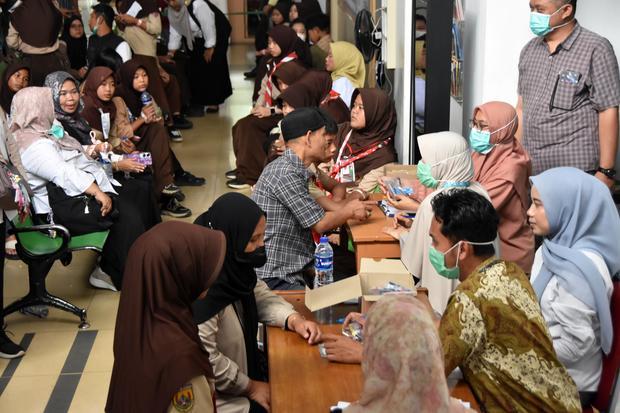 Petugas kesehatan menyerahkan obat kepada siswa SMPN 2 Cisarua di Instalasi Rawat Jalan RS Goenawan Partowidigdo, Cisarua, Bogor, Jawa Barat, Rabu (21/10/2026). Bupati Bogor Rudy Susmanto mengatakan berdasarkan data sementara tercatat sebanyak 103 orang siswa SMPN 2 Cisarua, Bogor diduga mengalami gejala keracunan dan tim dari Dinas Kesehatan Kabupaten Bogor sudah mengambil sampel makanan dan minuman yang sempat disantap oleh para korban untuk diteliti.