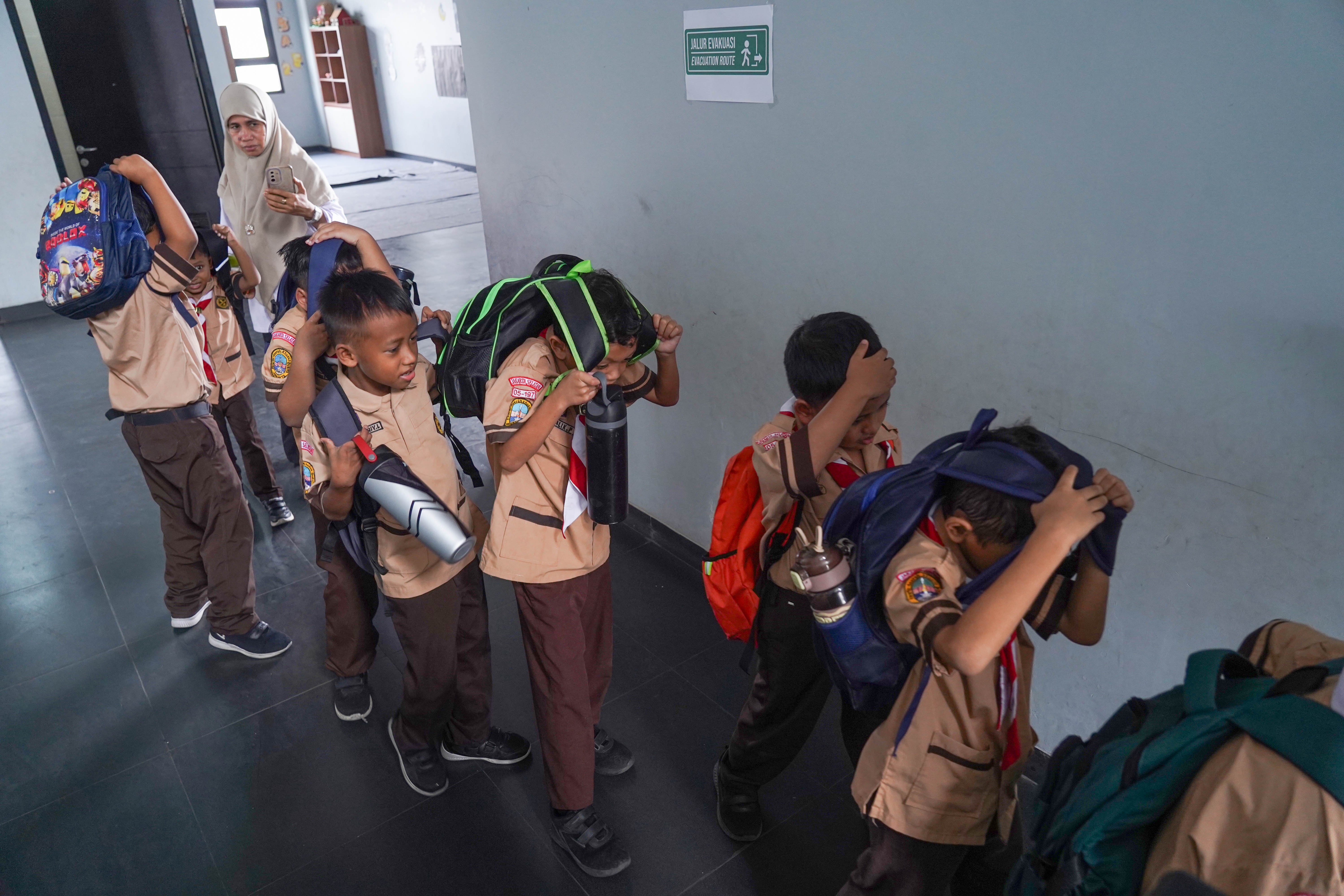 Guru dan siswa berlari menuju lapangan saat mengikuti simulasi gempa bumi di SDN Pejaten Timur 11, Jakarta, Rabu (21/10/26). Pemerintah Provinsi DKI Jakarta menggelar simulasi gempa bumi serentak pada 21 Oktober 2026 di gedung perkantoran pemerintah, kantor kecamatan dan kelurahan hingga sekolah dalam rangka meningkatkan kesiapsiagaan menghadapi potensi bencana gempa bumi.