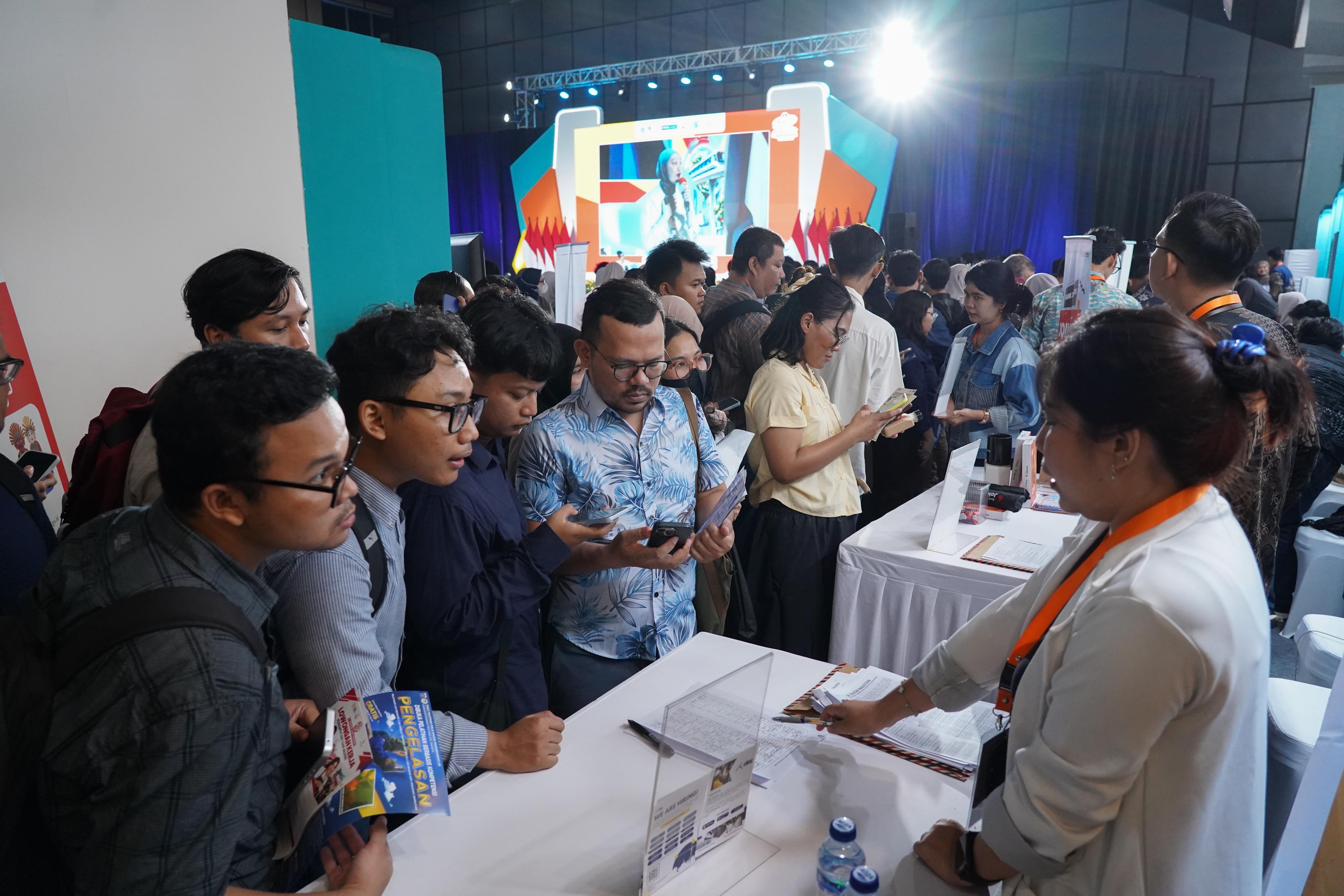 Pencari kerja melihat informasi lowongan kerja yang tersedia saat berlangsungnya bursa kerja di Convention Hall SMESCO, Pancoran, Jakarta, Kamis (22/10/2026). Bursa kerja yang menghadirkan 65 perusahaan dengan peluang kerja dalam negeri dan 10 perusahaan dengan peluang kerja luar negeri ini digelari pada 22-23 Oktober 2026.
