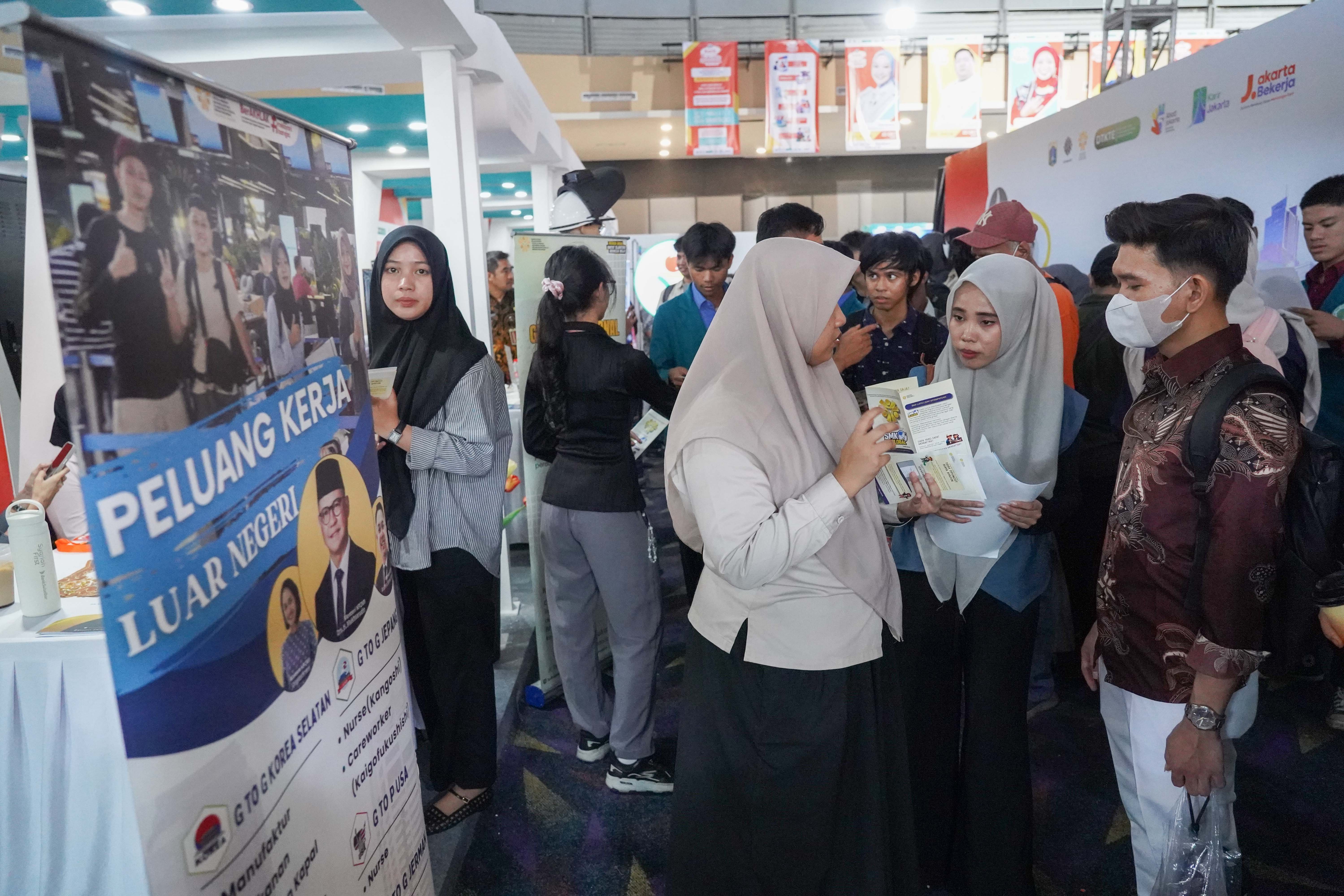 Petugas memberikan informasi terkait lowongan kerja yang tersedia kepada pencari kerja saat berlangsungnya bursa kerja di Convention Hall SMESCO, Pancoran, Jakarta, Kamis (22/10/2026). Bursa kerja yang menghadirkan 65 perusahaan dengan peluang kerja dalam negeri dan 10 perusahaan dengan peluang kerja luar negeri ini digelar pada 22-23 Oktober 2026.
