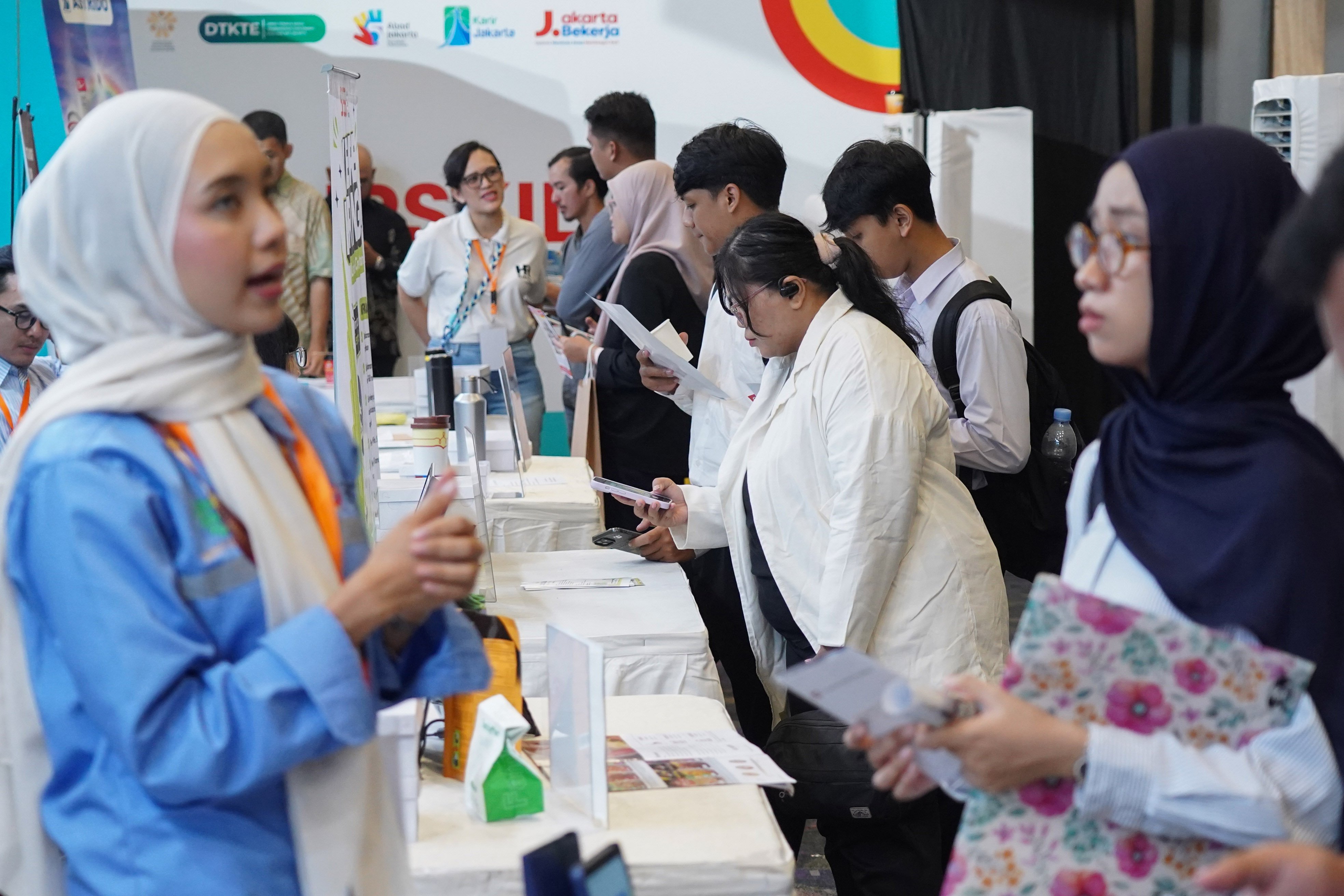 Pencari kerja melihat informasi lowongan kerja yang tersedia saat berlangsungnya bursa kerja di Convention Hall SMESCO, Pancoran, Jakarta, Kamis (22/10/2026). Bursa kerja yang menghadirkan 65 perusahaan dengan peluang kerja dalam negeri dan 10 perusahaan dengan peluang kerja luar negeri ini digelar pada 22-23 Oktober 2026.