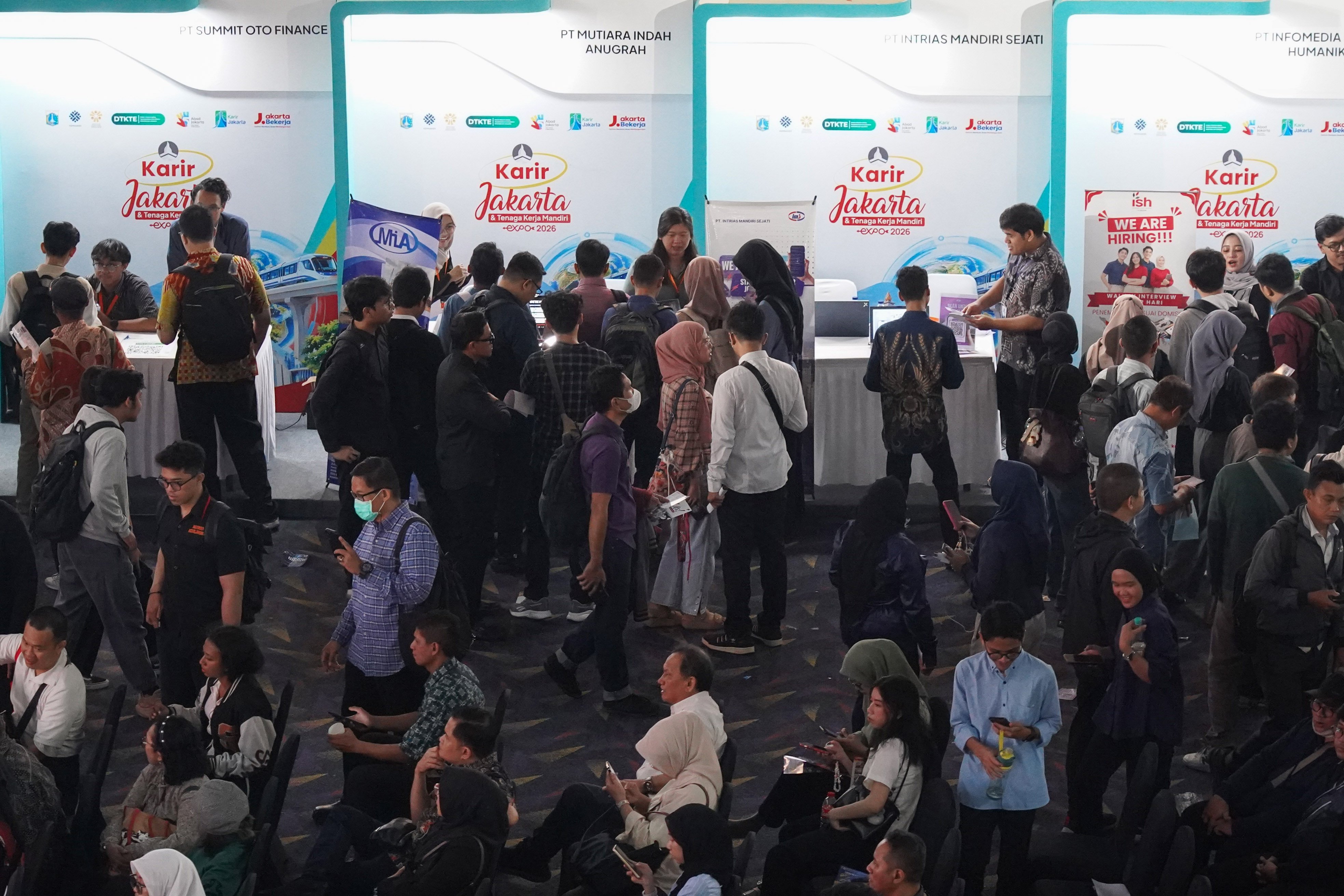 Pencari kerja melihat informasi lowongan kerja yang tersedia saat berlangsungnya bursa kerja di Convention Hall SMESCO, Pancoran, Jakarta, Kamis (22/10/2026). Bursa kerja yang menghadirkan 65 perusahaan dengan peluang kerja dalam negeri dan 10 perusahaan dengan peluang kerja luar negeri ini digelar pada 22-23 Oktober 2026.
