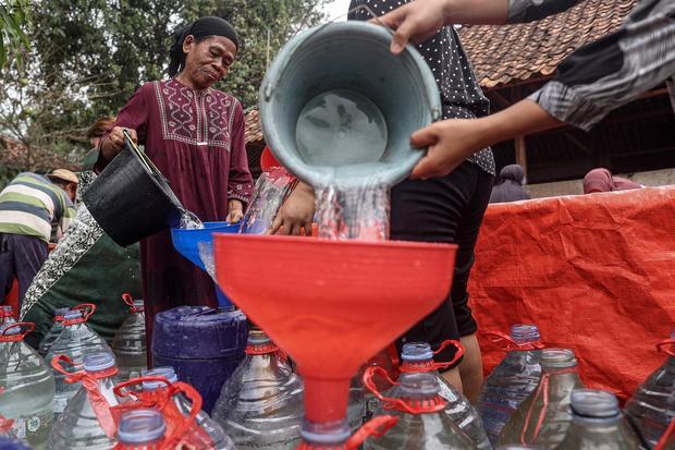 Sejumlah warga mengisi tabung galon dengan air bersih dari tangki di Desa Medalkrisna, Bojongmangu, Kabupaten Bekasi, Jawa Barat, Selasa (27/10/2026). Palang Merah Indonesia (PMI) Kabupaten Bekasi mendistribusikan 30.000 liter air bersih kepada 255 kepala keluarga (KK) di dua kecamatan di daerah tersebut yang masih mengalami kekeringan akibat musim kemarau berkepanjangan.